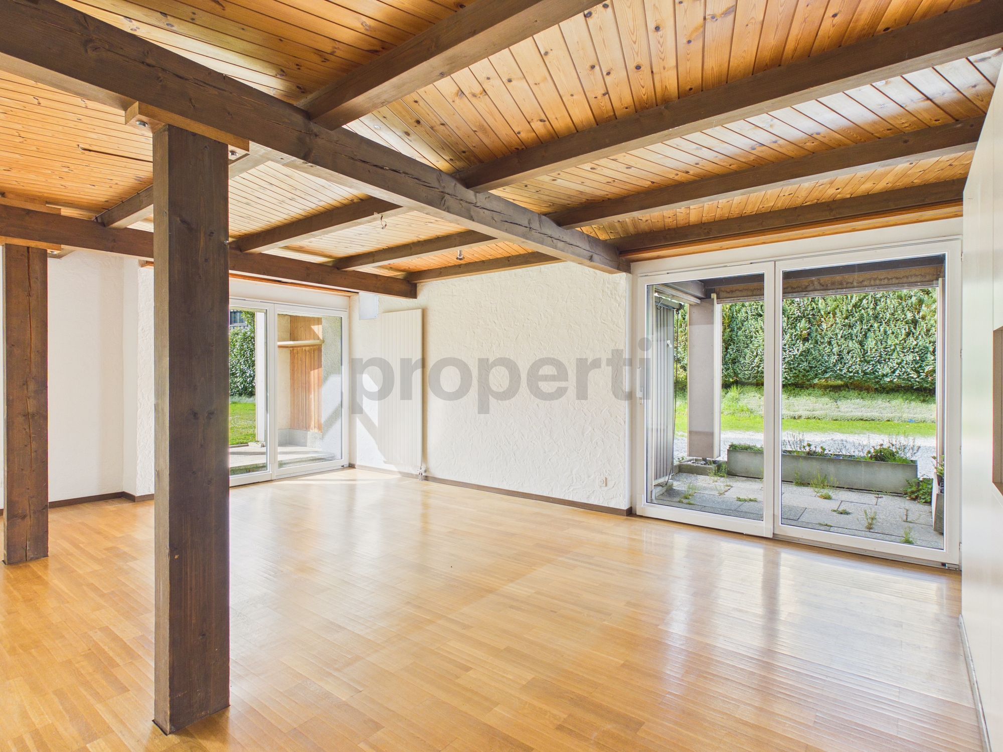 Heller Wohnraum mit Holzdecke und Terrassentüren