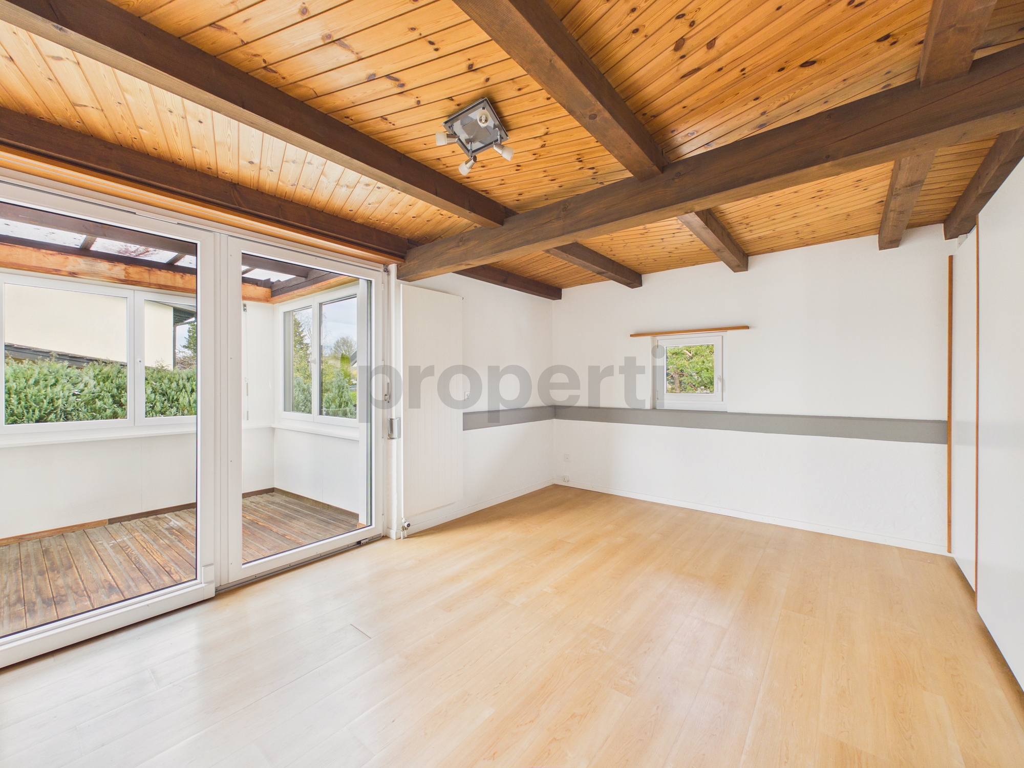 Heller leerer Raum mit Holzdecke und Terrasse