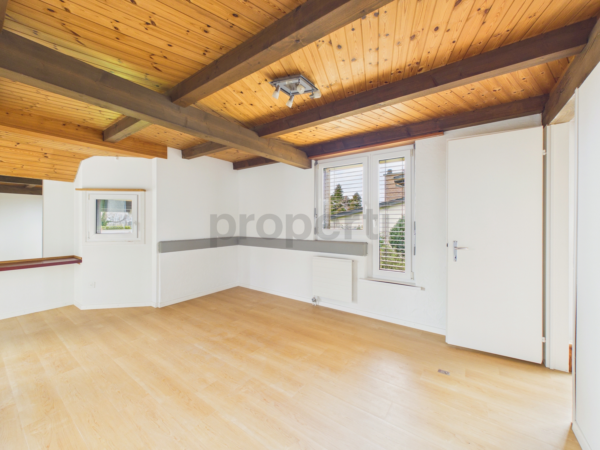 Leeres Dachgeschosszimmer mit Holzdecke