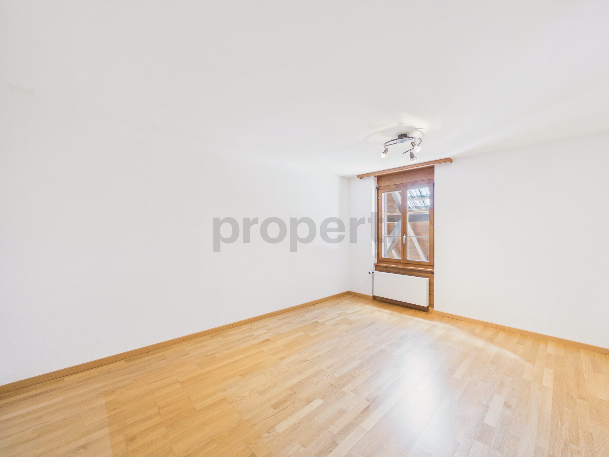 Leeres helles Zimmer mit Parkett und Fenster