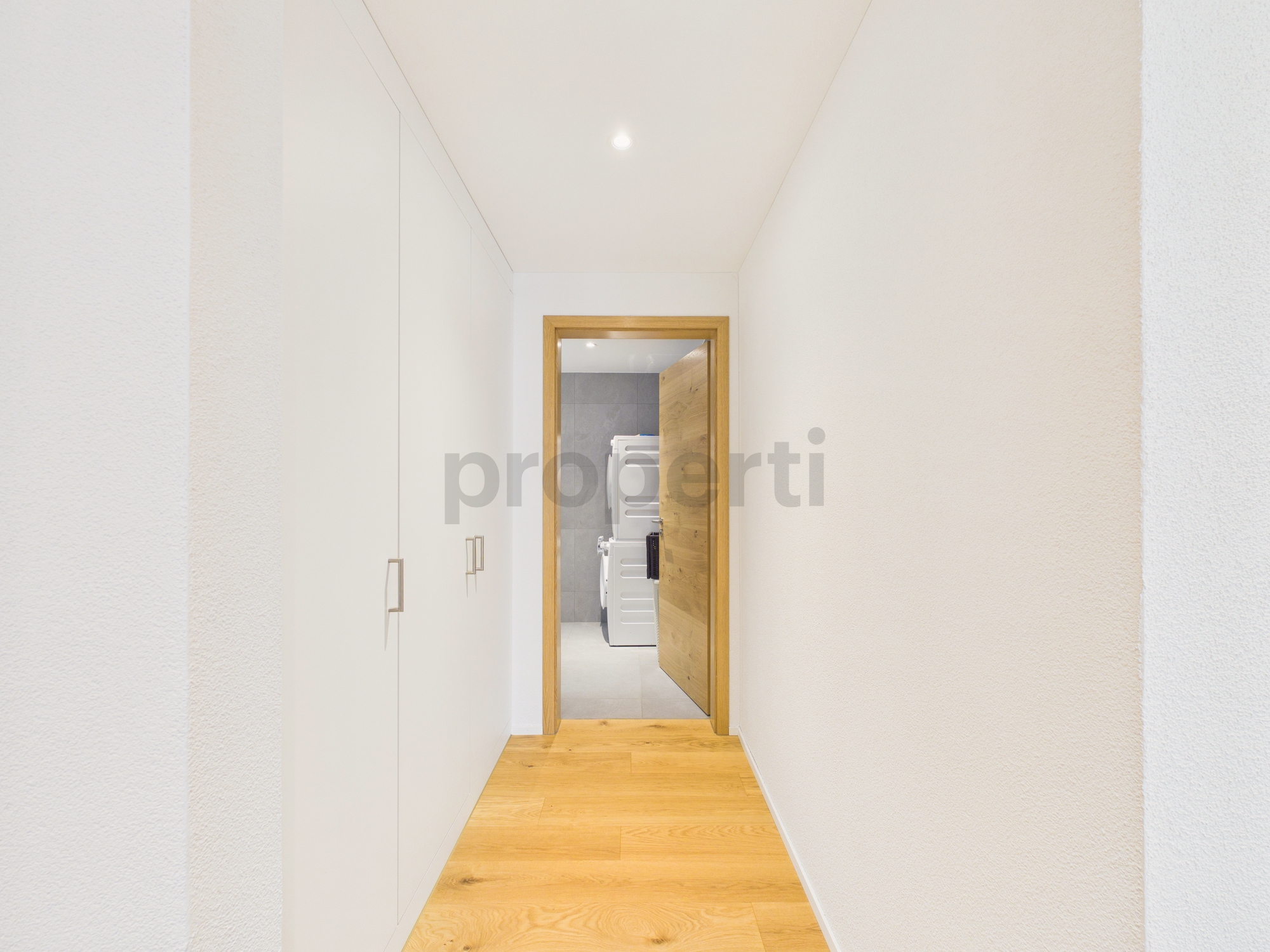 Schmaler Flur mit Blick in einen Hauswirtschaftsraum