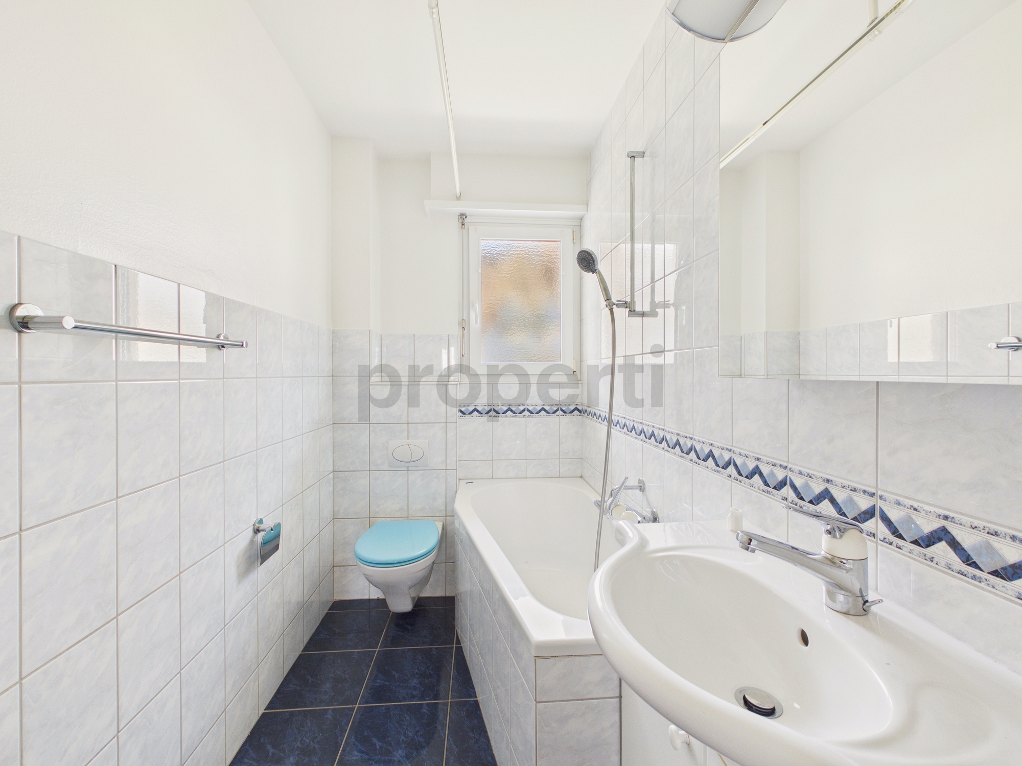 Schmales Badezimmer mit Badewanne und WC