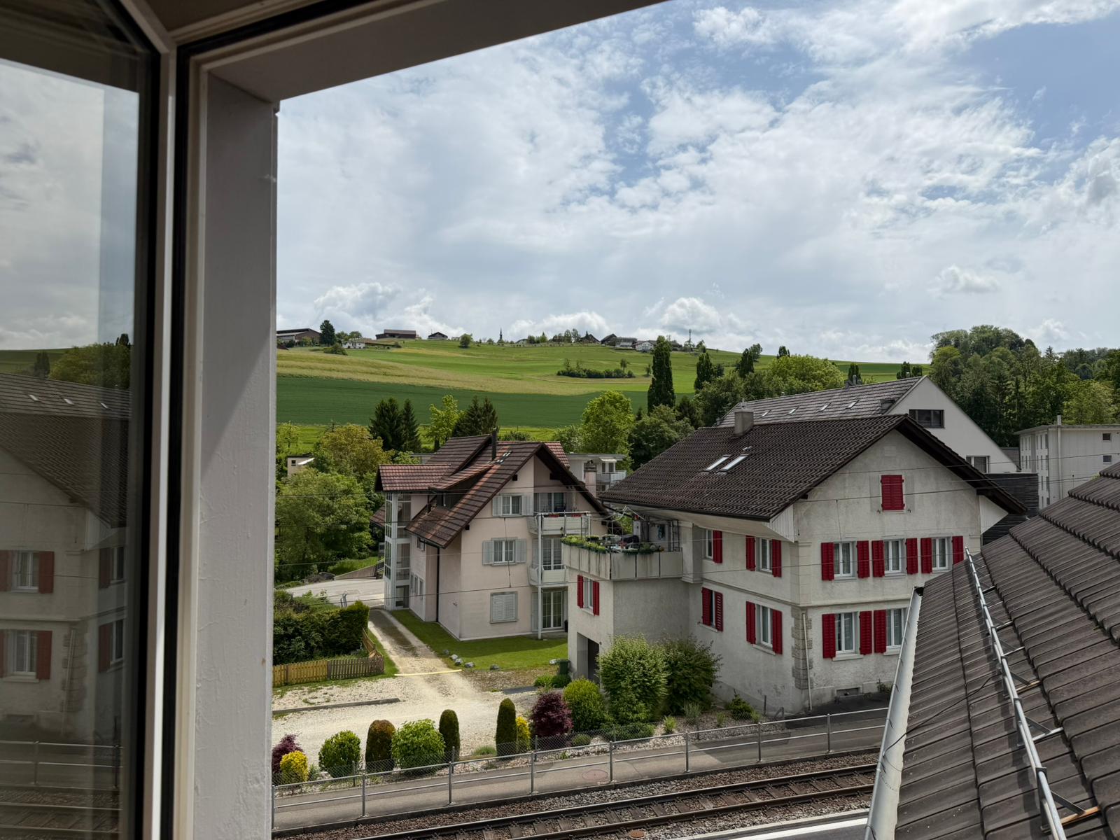 Ausblick aus dem Fenster auf Wohnhäuser und Landschaft