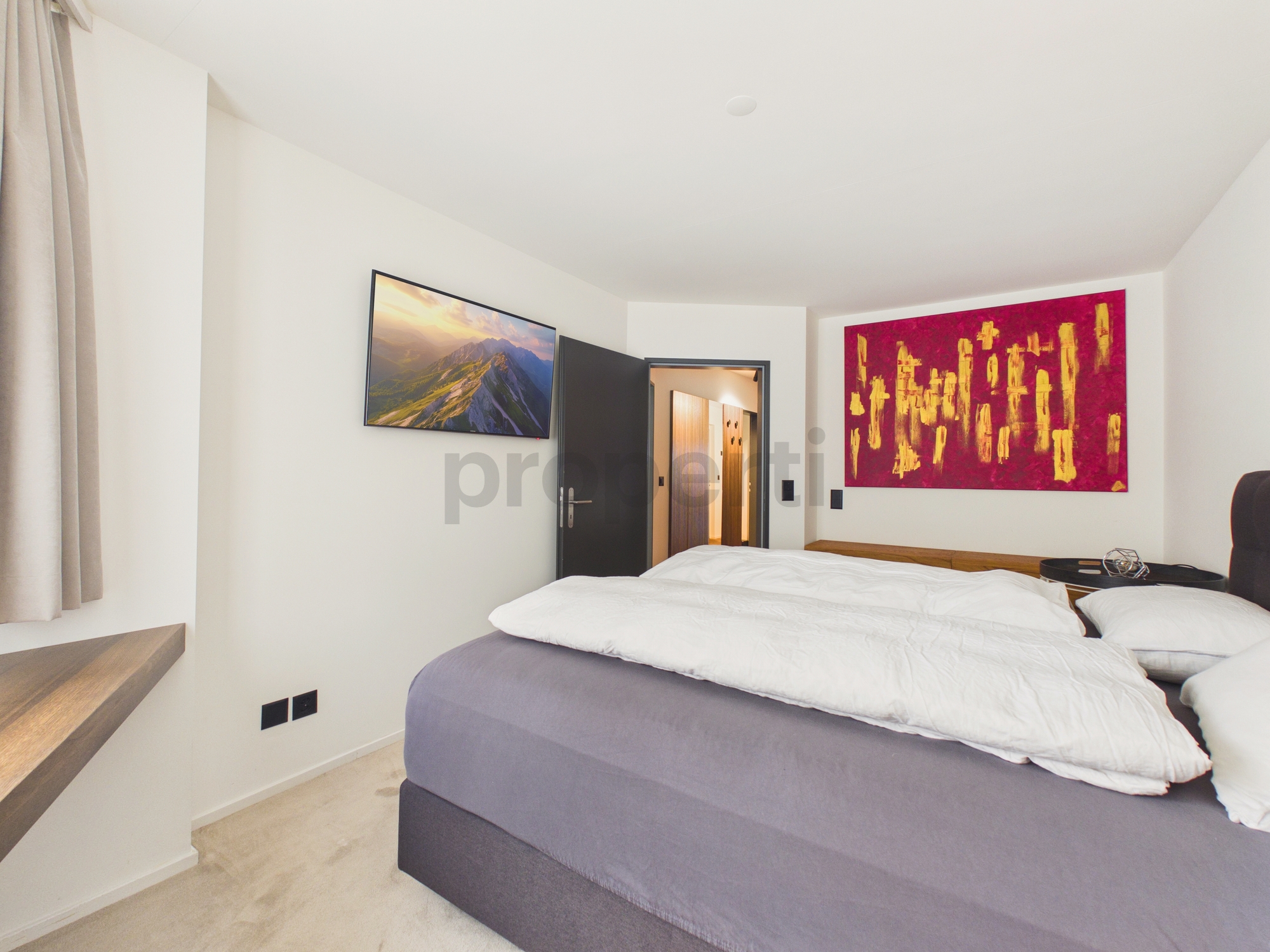 Modernes Schlafzimmer mit Doppelbett und Kunstwerken