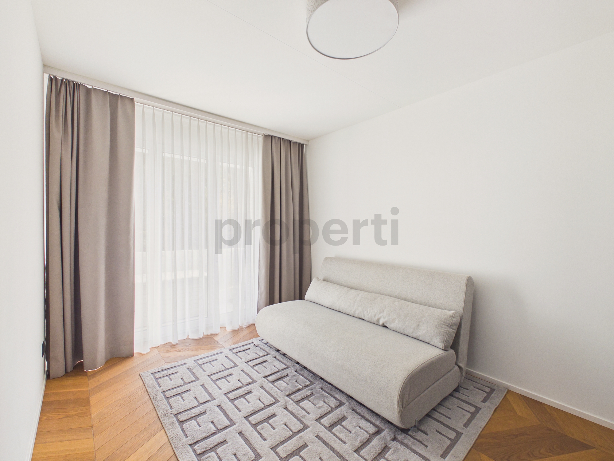 Helles, minimalistisches Wohnzimmer mit Sofa und großem Fenster