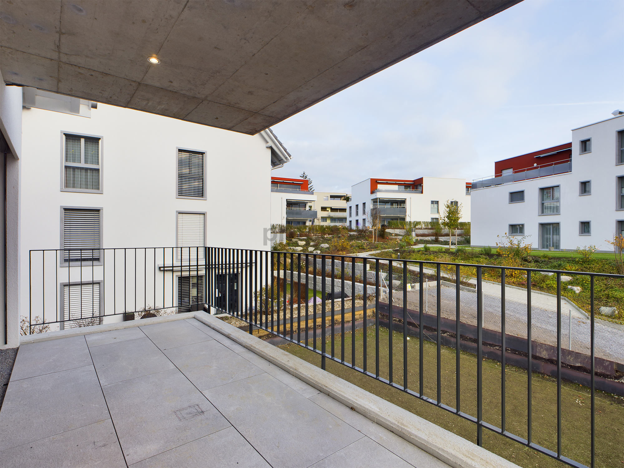 Überdachter Balkon mit Blick auf Wohnanlage