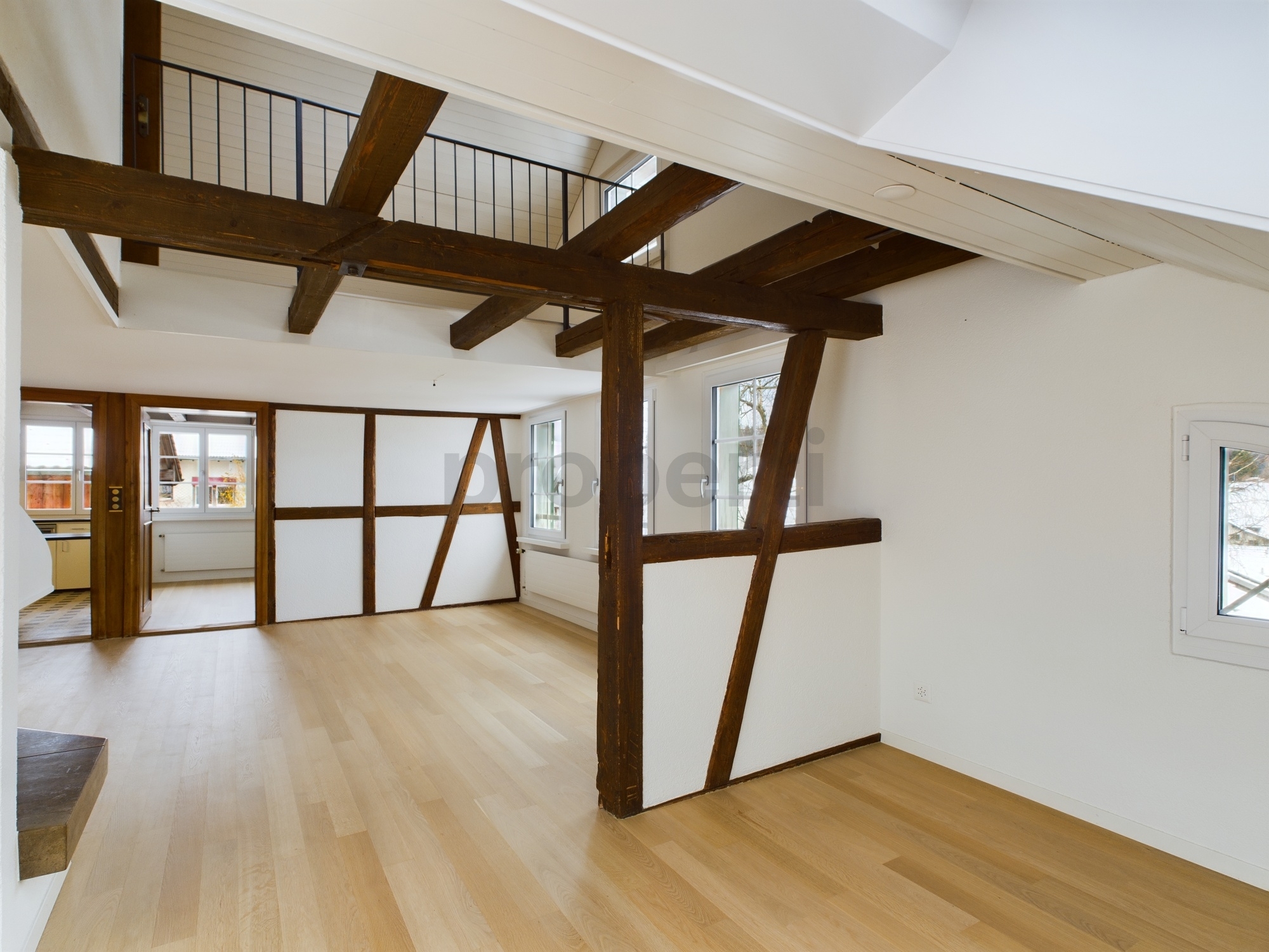 Heller Innenraum mit sichtbaren Holzbalken und Galerie