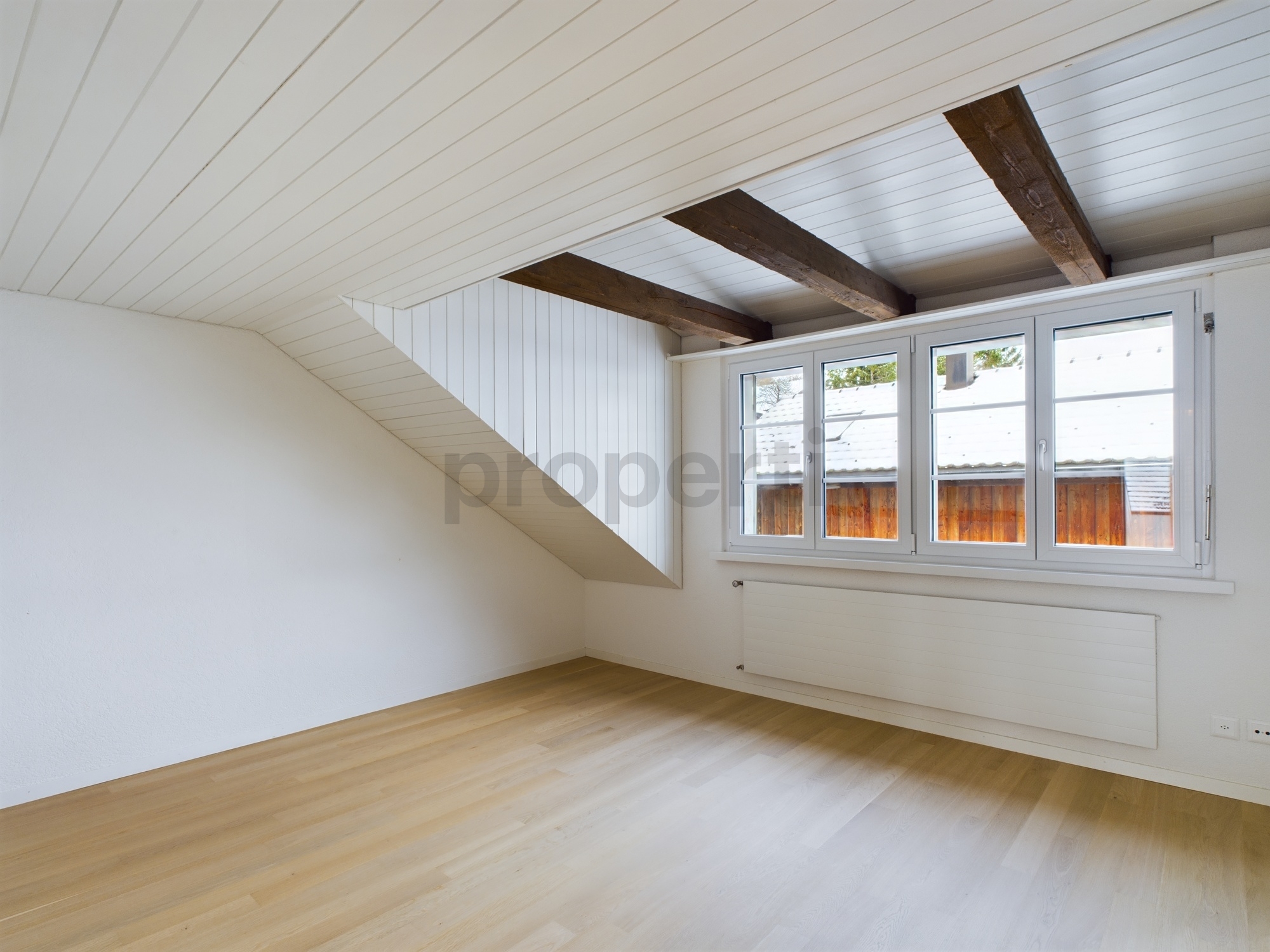 Helles Dachgeschosszimmer mit sichtbaren Balken