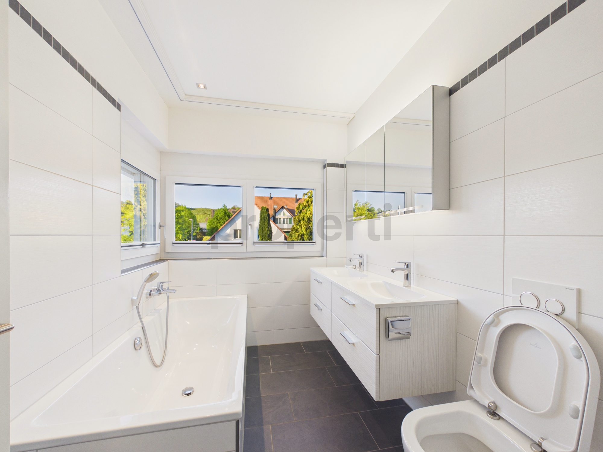 Modernes Badezimmer mit Badewanne, Waschtisch und WC