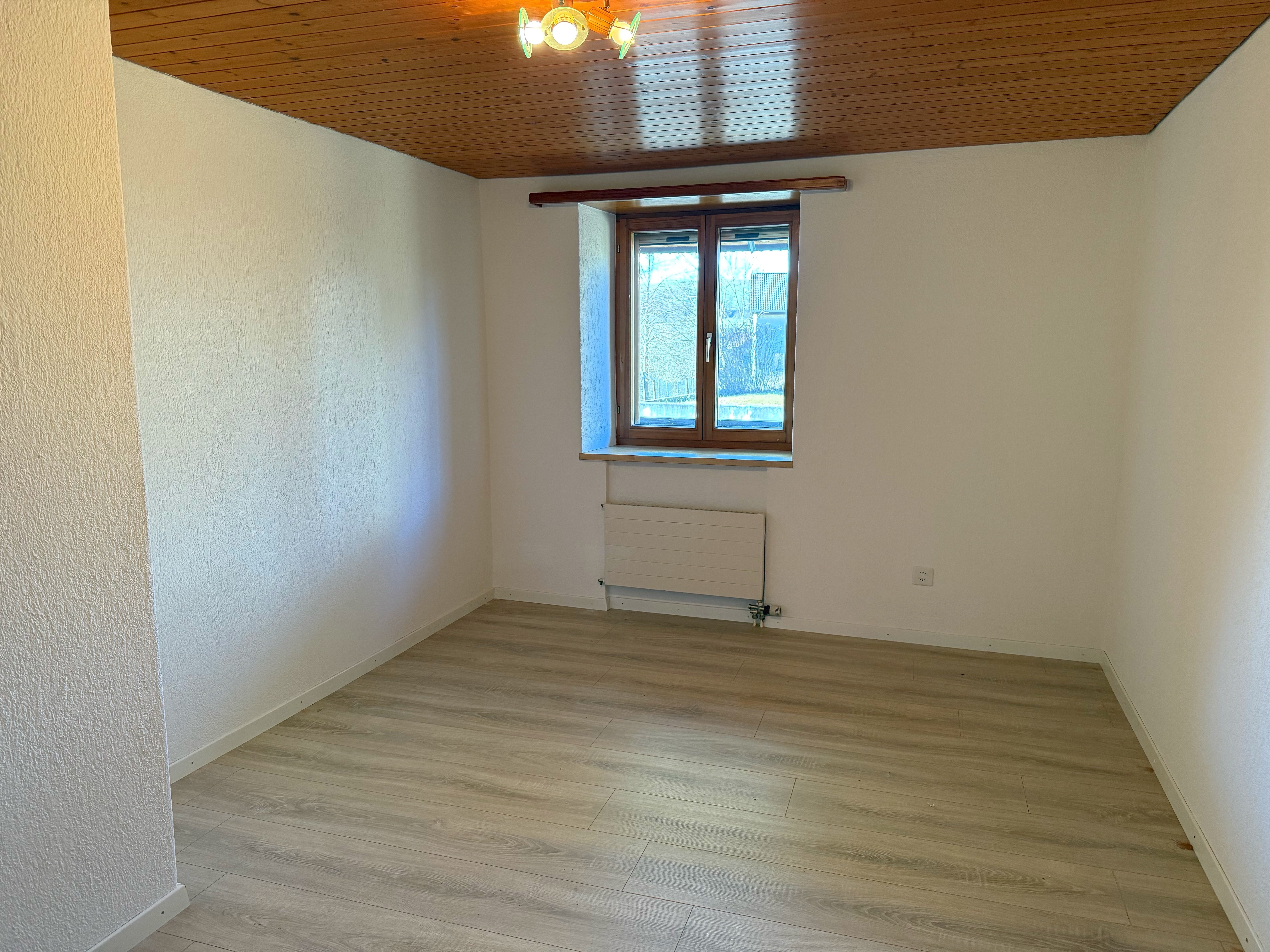Leerer Raum mit Holzdecke und Fenster