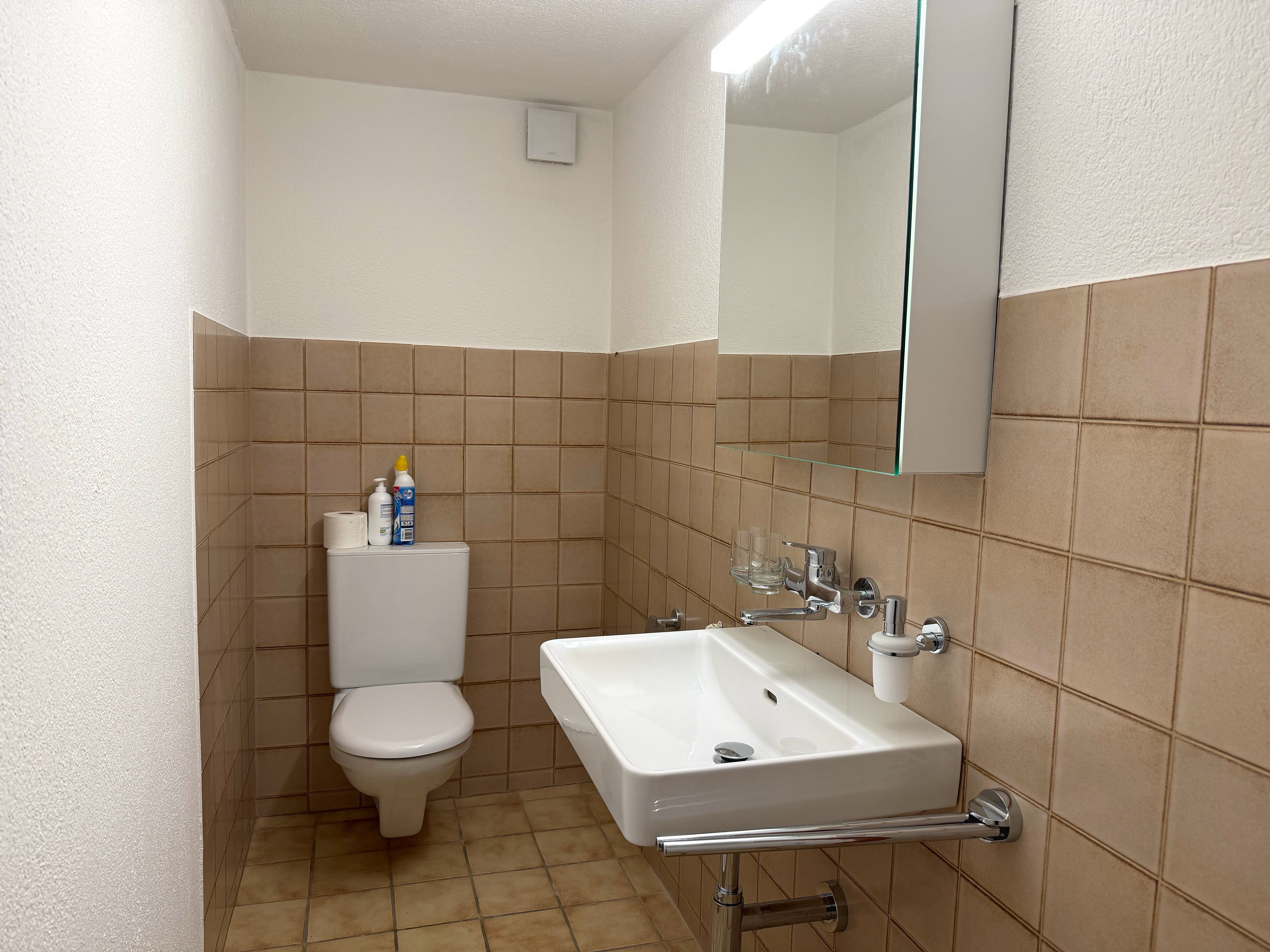 Gäste-WC mit Waschbecken und wandhängendem WC