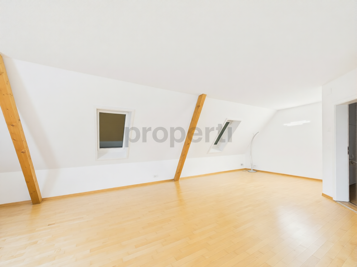 Heller Dachgeschossraum mit sichtbaren Holzbalken