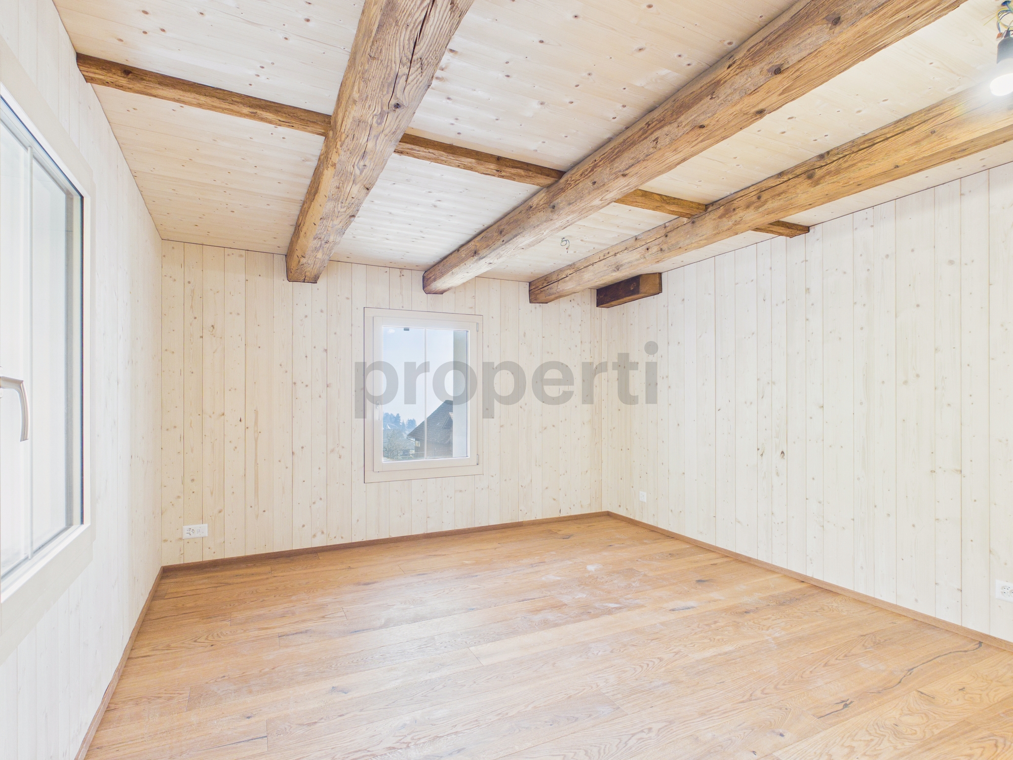 Leerer, heller Raum mit sichtbaren Holzbalken