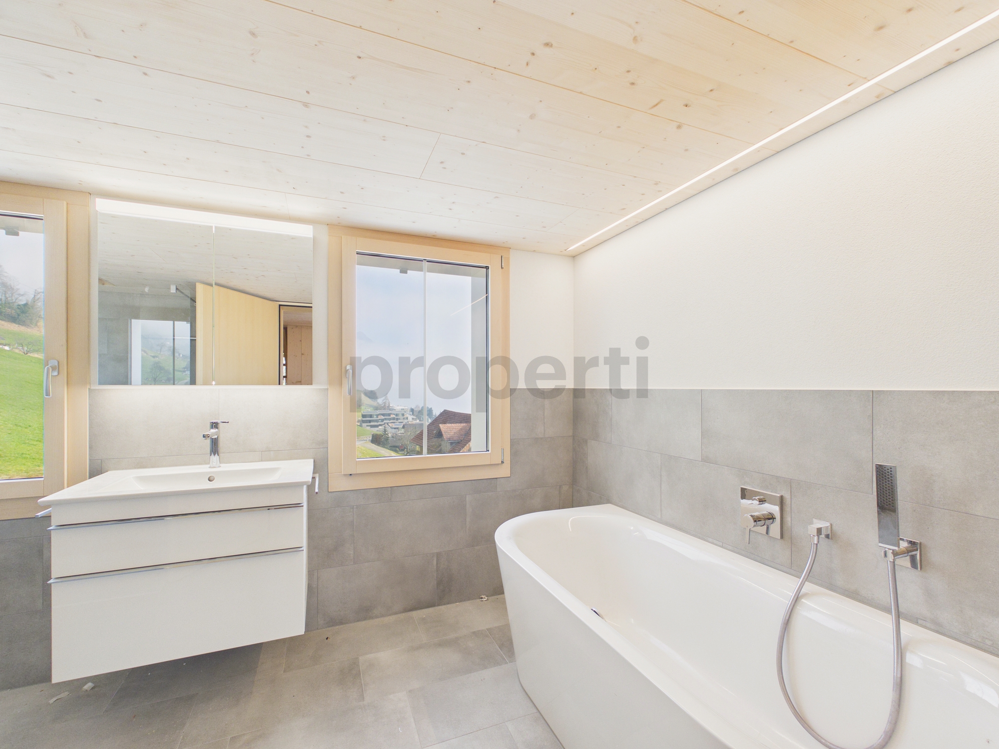 Modernes Badezimmer mit Badewanne und Fensterblick