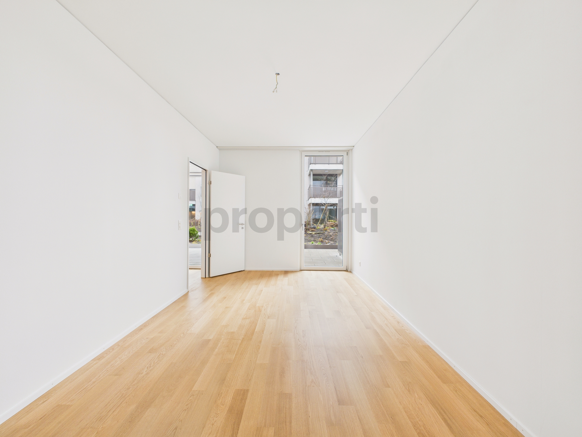 Leeres, helles Zimmer mit Holzboden