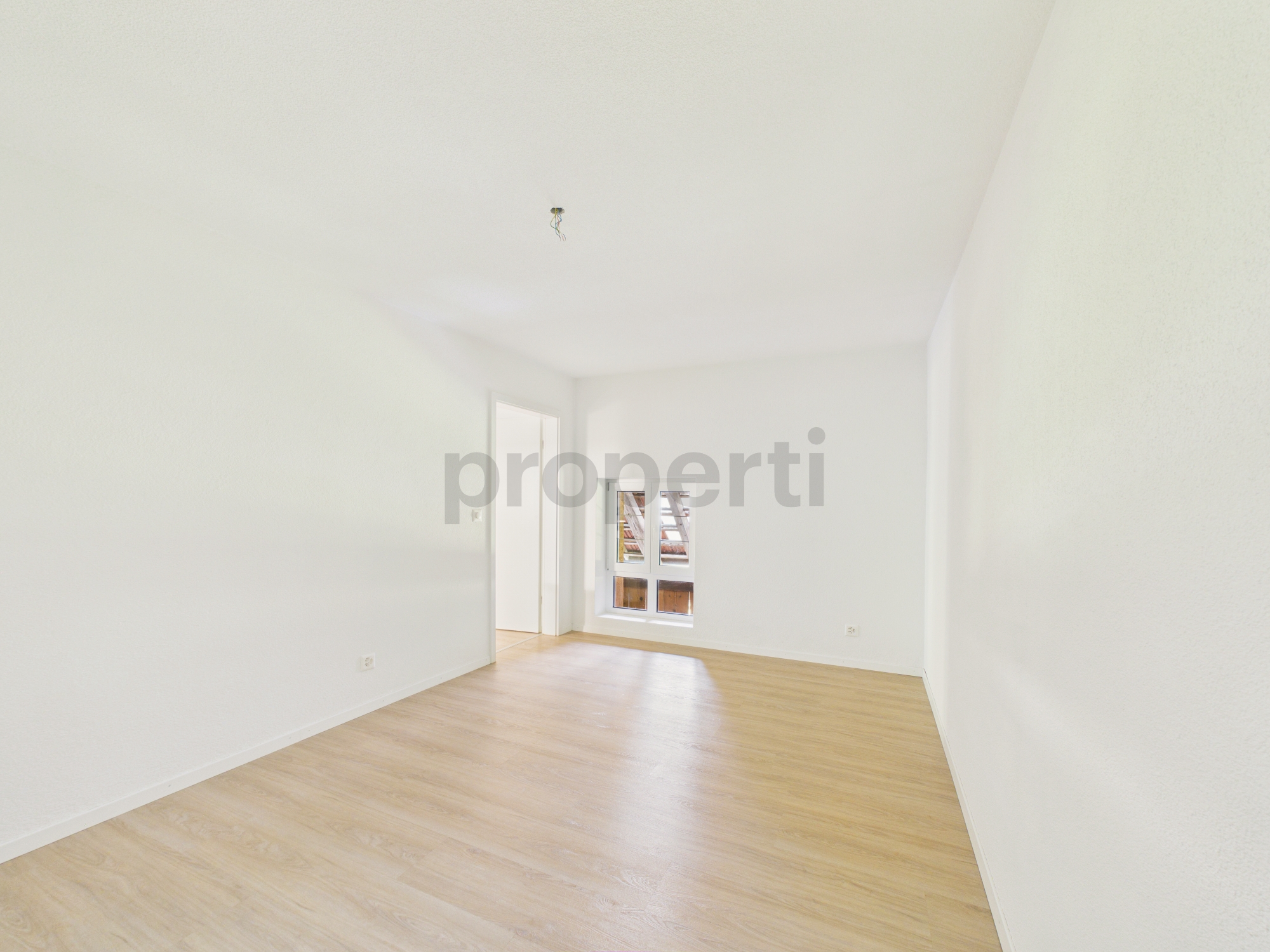 Helles, leeres Zimmer mit Holzboden