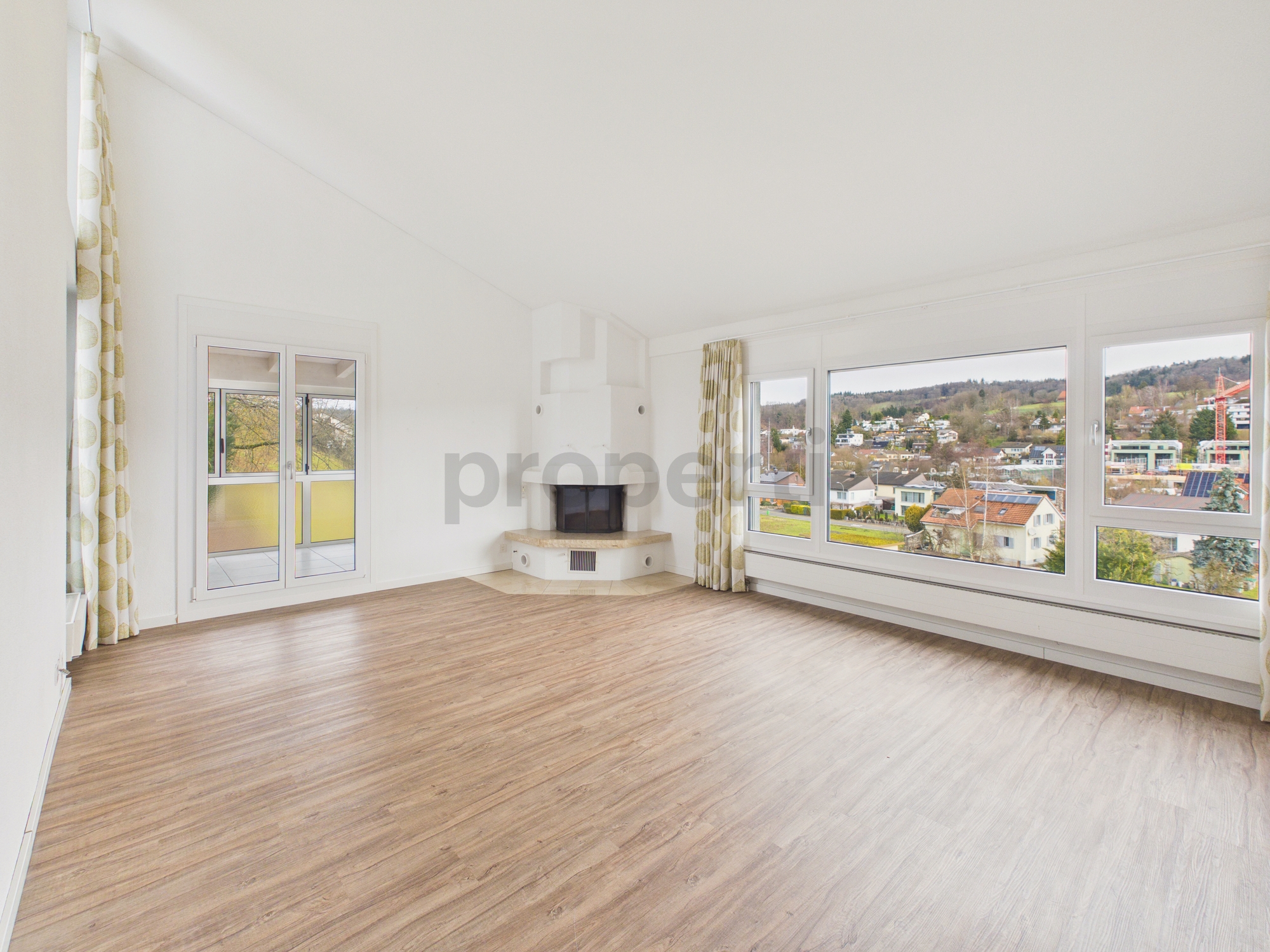 Heller Wohnraum mit Panoramafenstern und Kamin