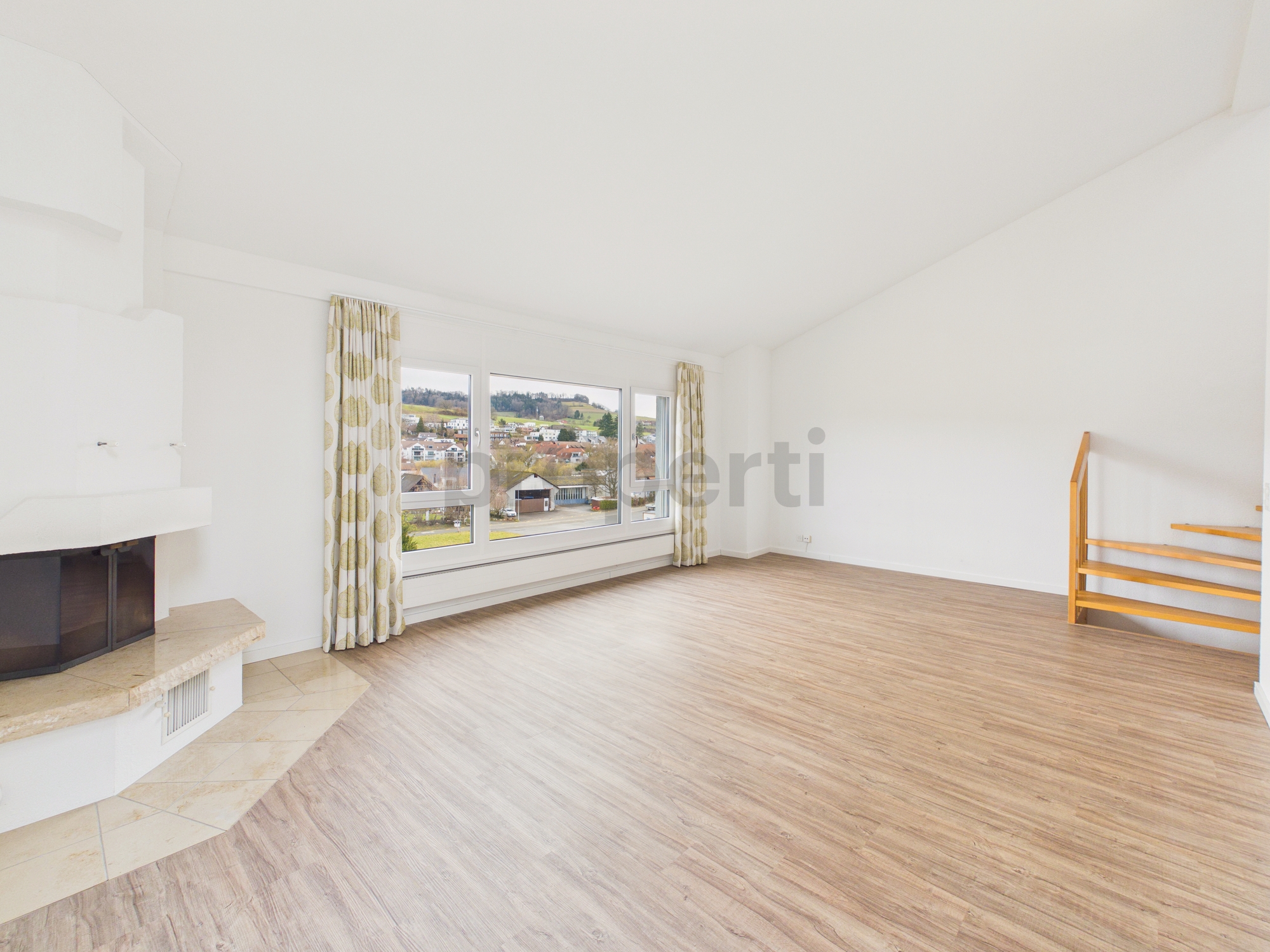 Heller Wohnraum mit Kamin und großem Fenster