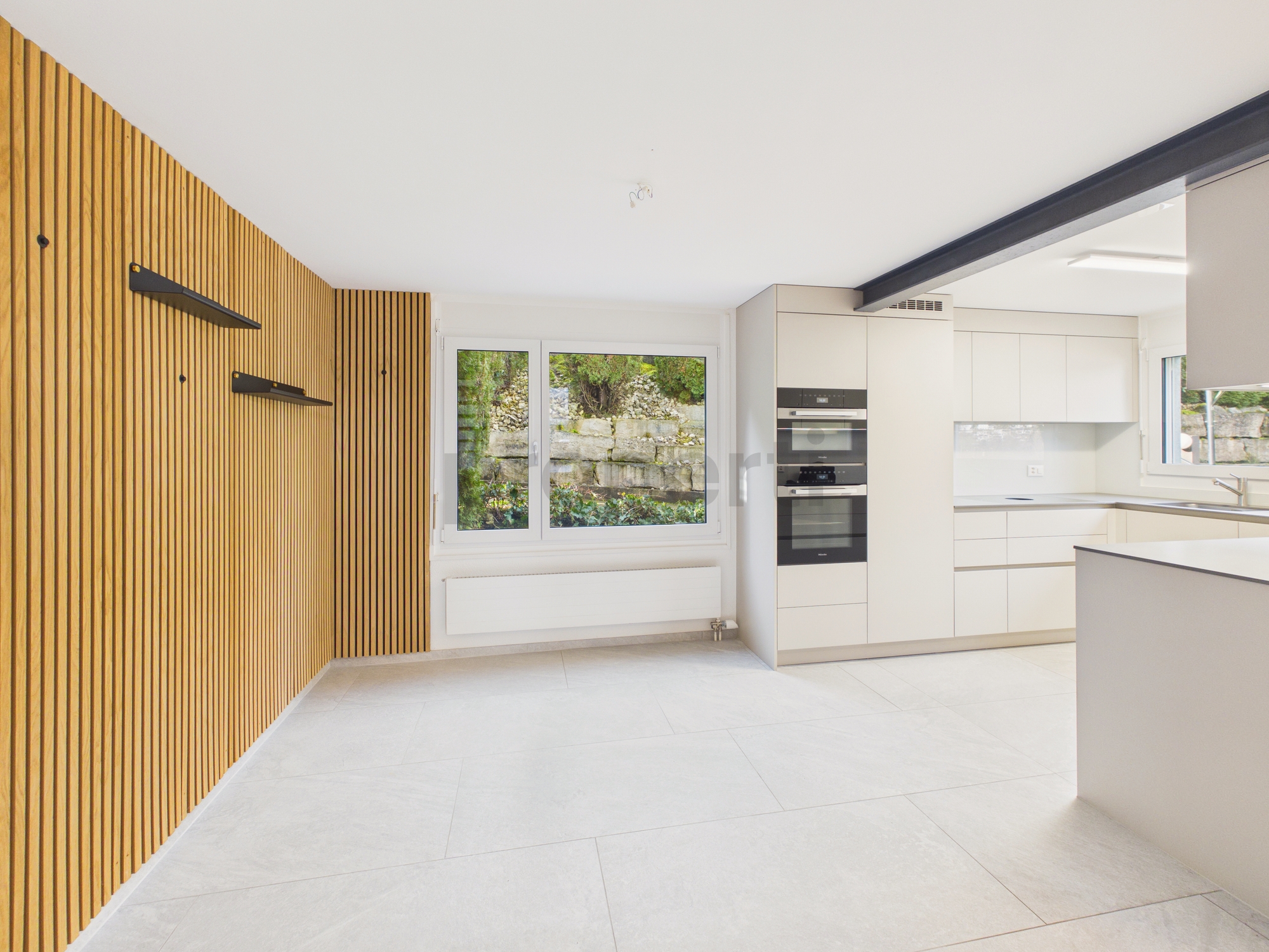 Moderne offene Küche mit Holzlamellenwand