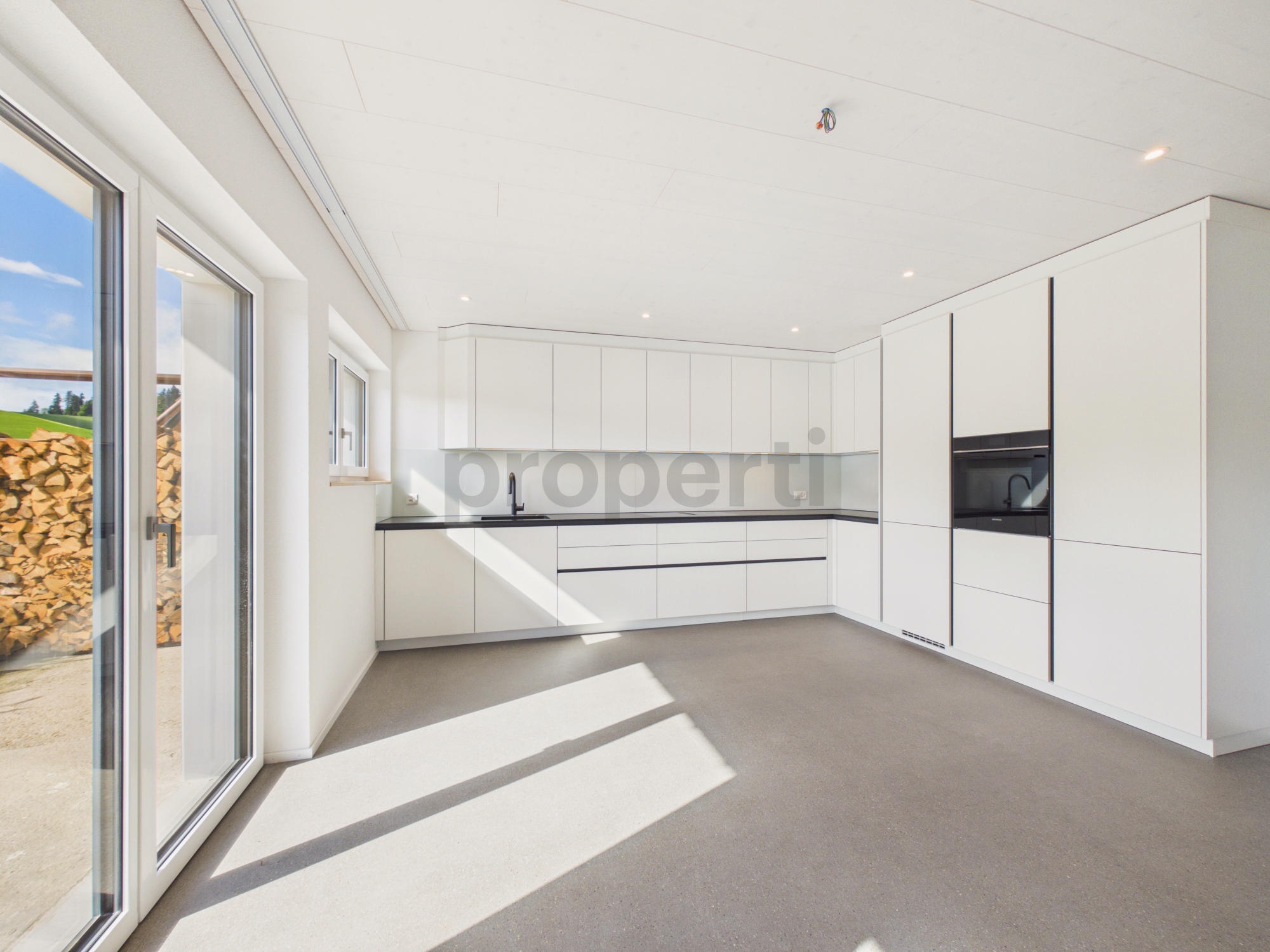 Moderne helle Küche mit großen Fensterflächen