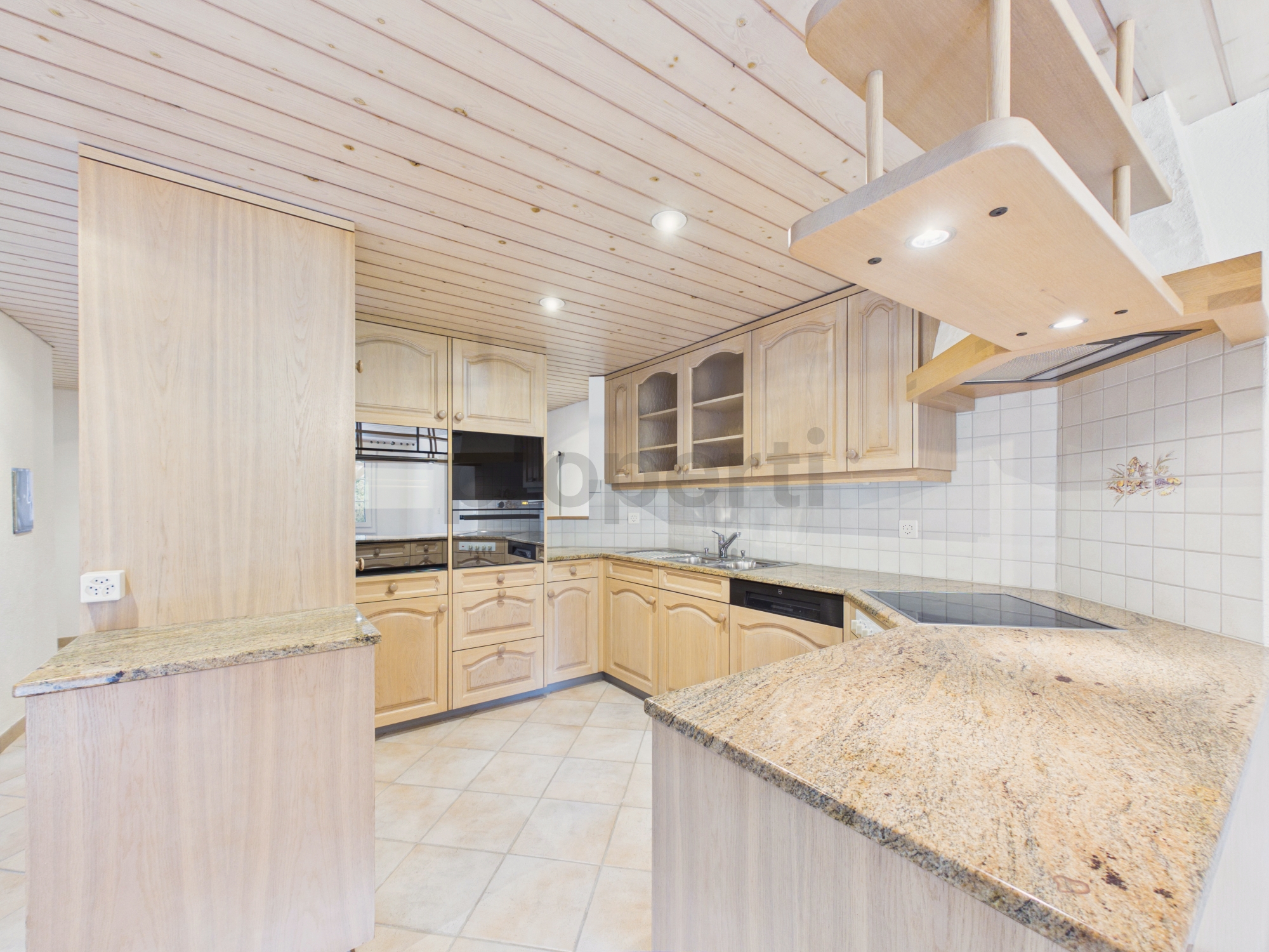 Helle Landhausküche mit Holzfronten und Granitarbeitsflächen