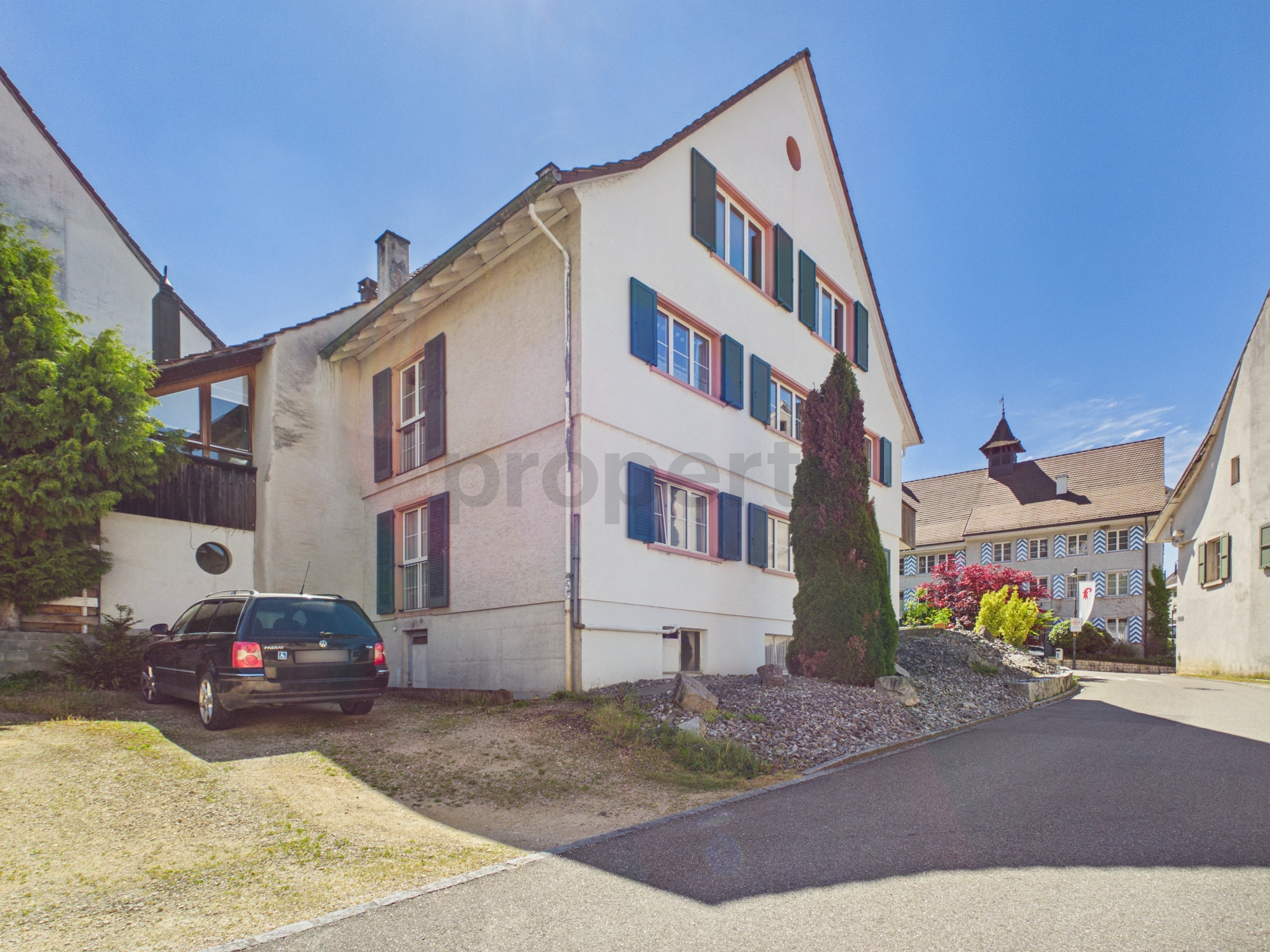 Helles Wohnhaus mit Satteldach und grünen Fensterläden