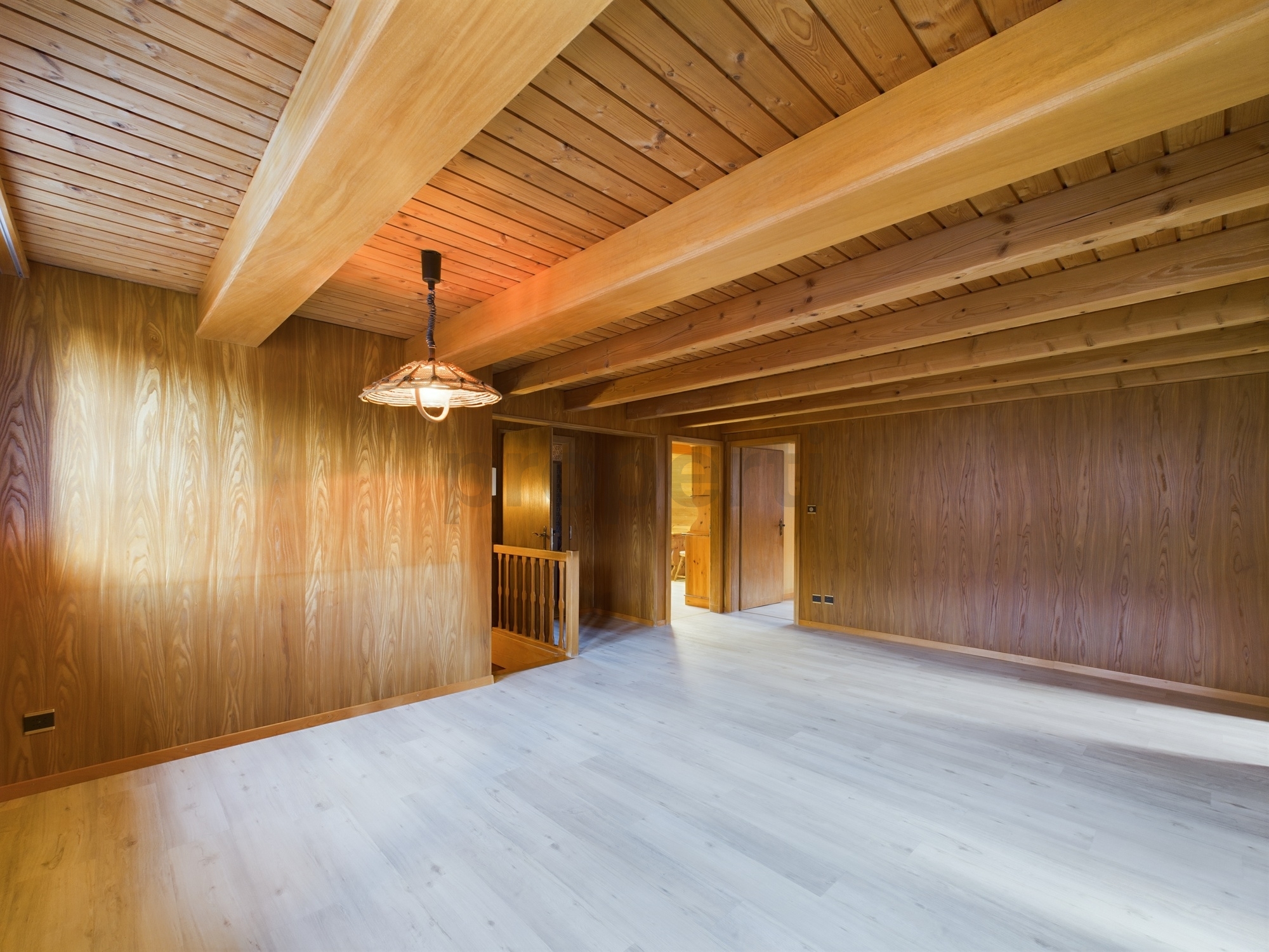 Holzvertäfelter Innenraum mit sichtbaren Deckenbalken