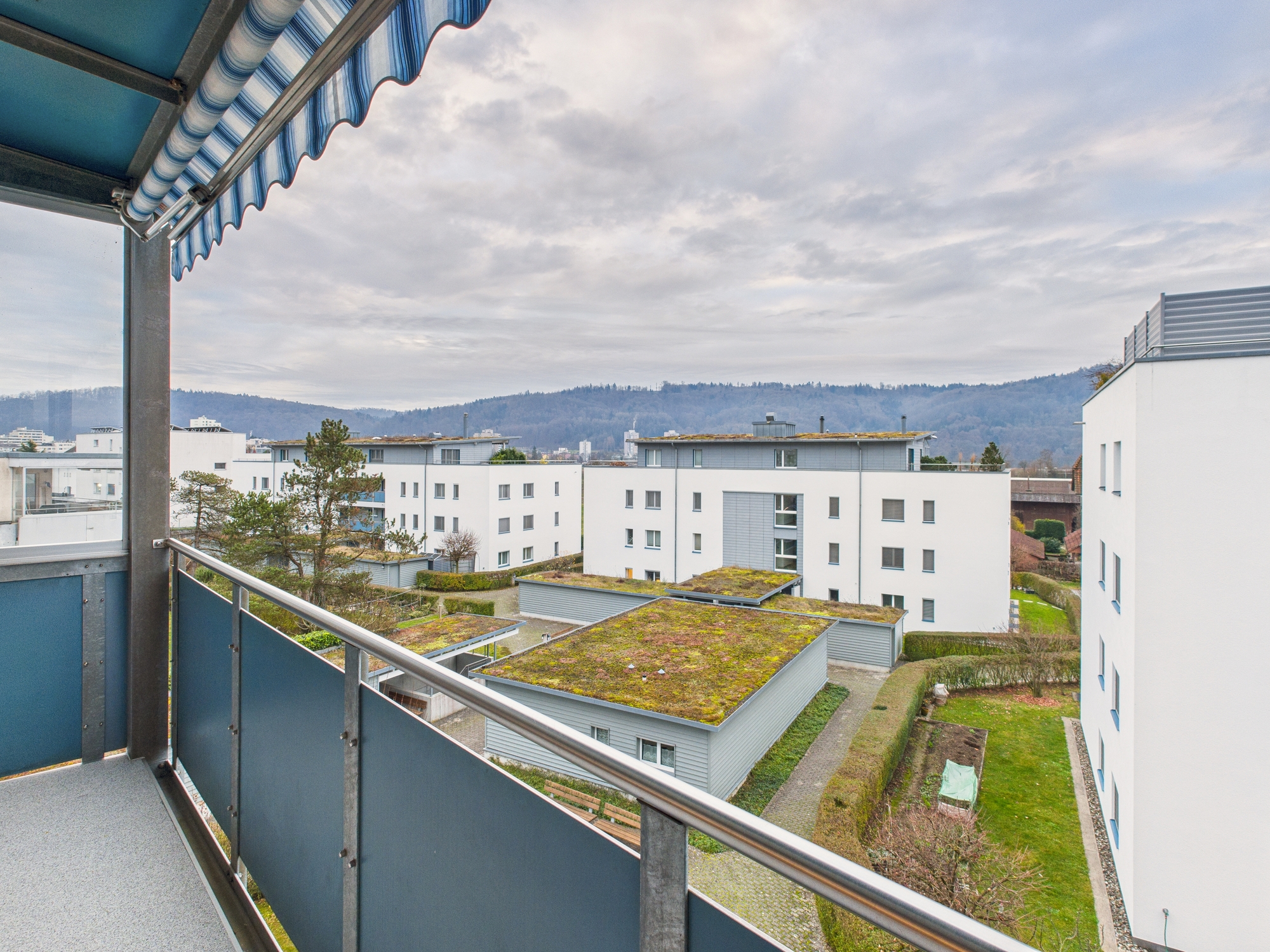 Balkon mit Blick auf Wohnanlage und Berge