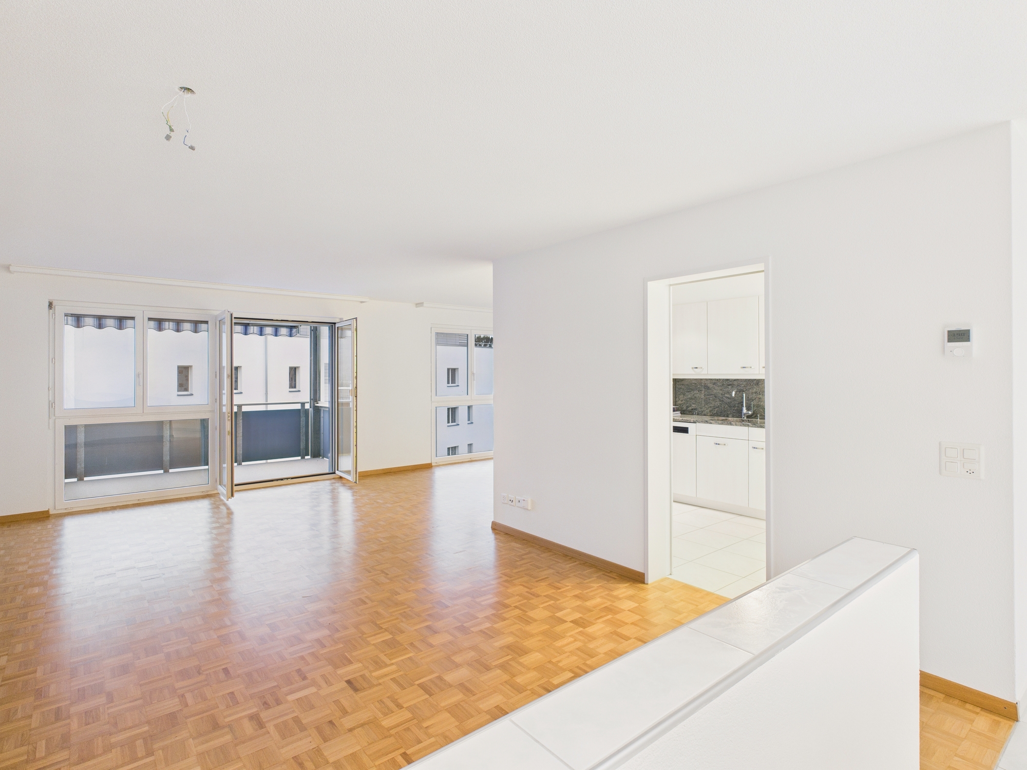 Heller Wohnraum mit Balkon und offener Sicht zur Küche
