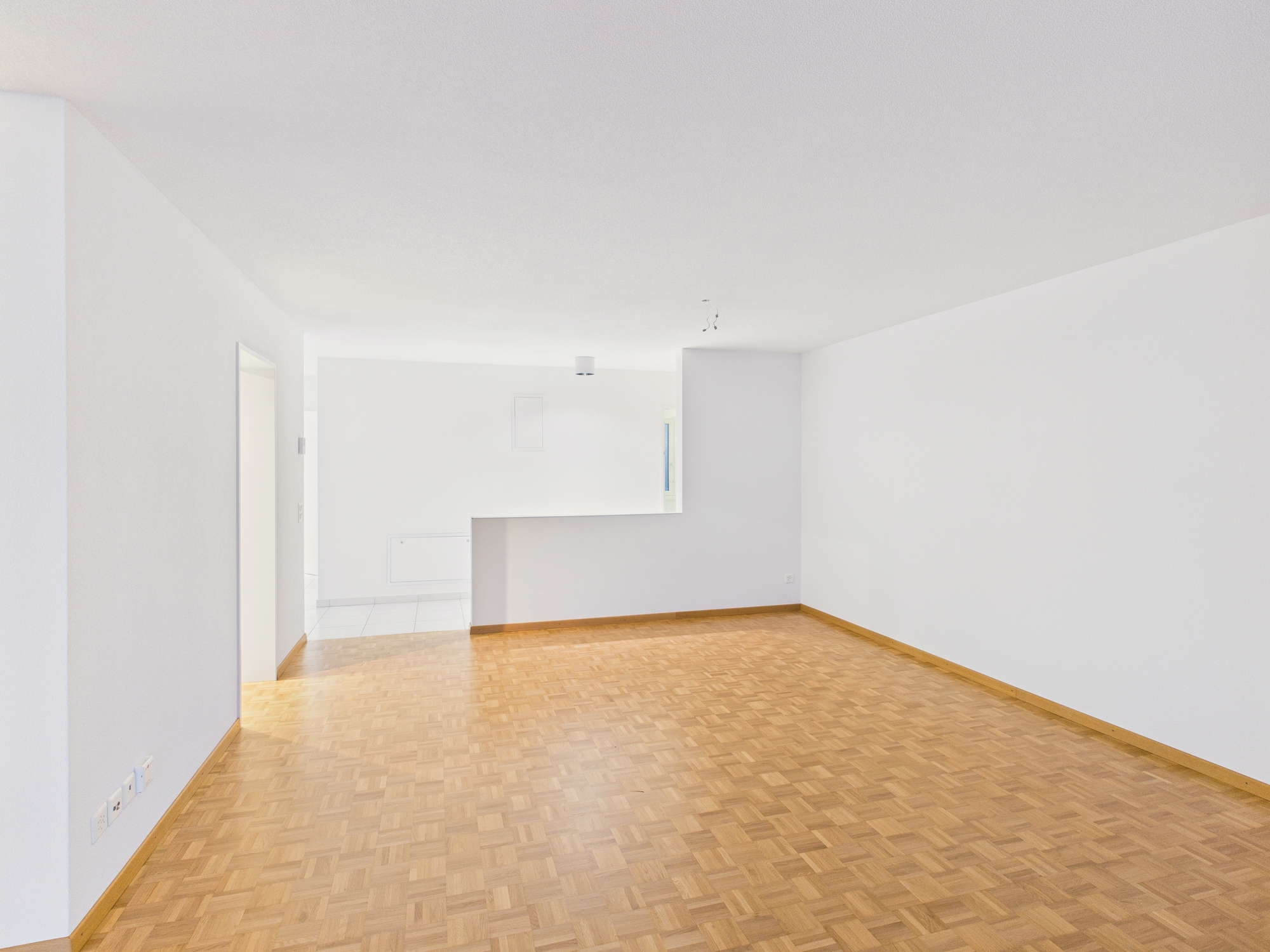 Leerer Wohnraum mit Parkettboden