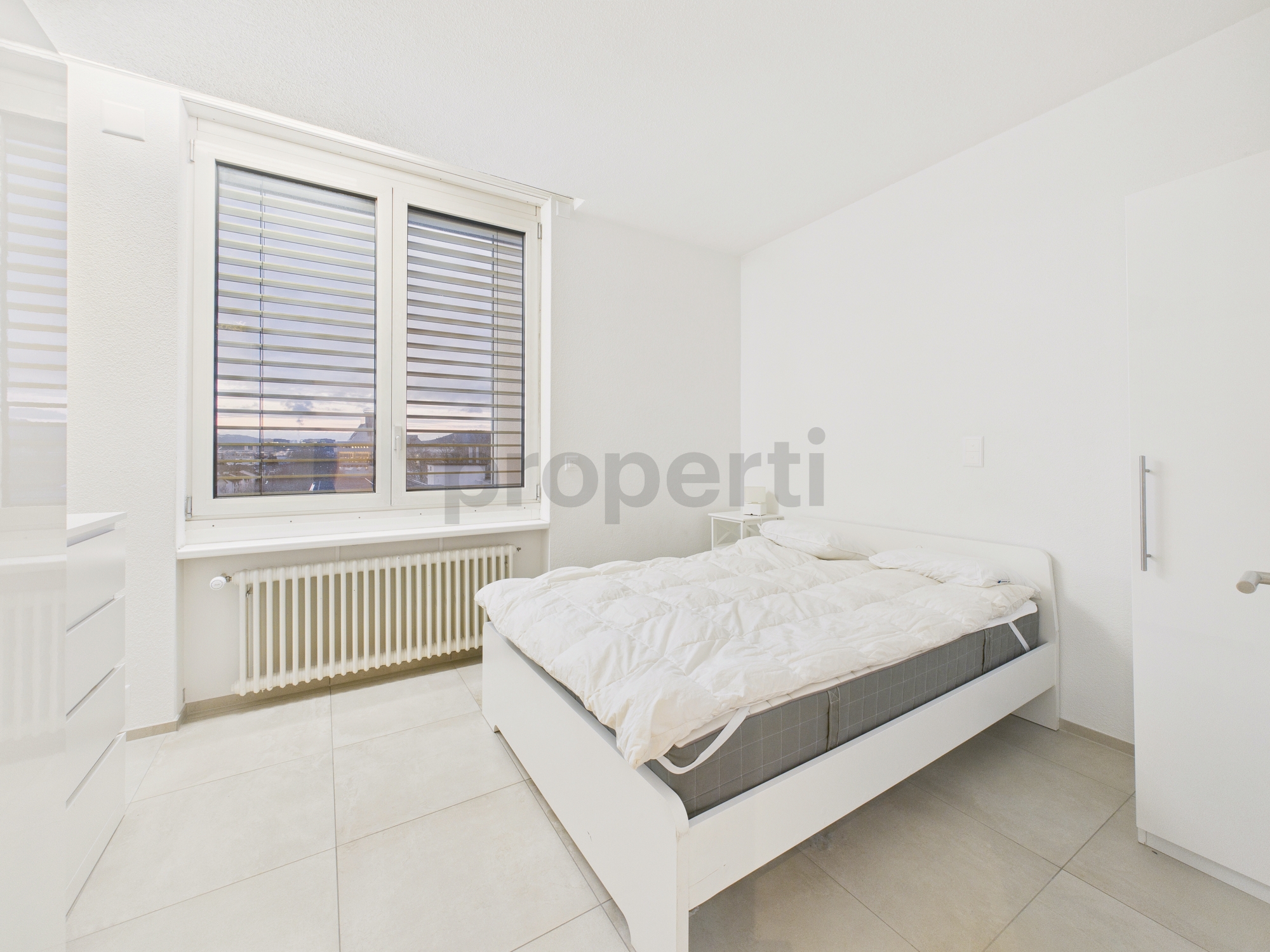 Helles Schlafzimmer mit Bett und Fenster