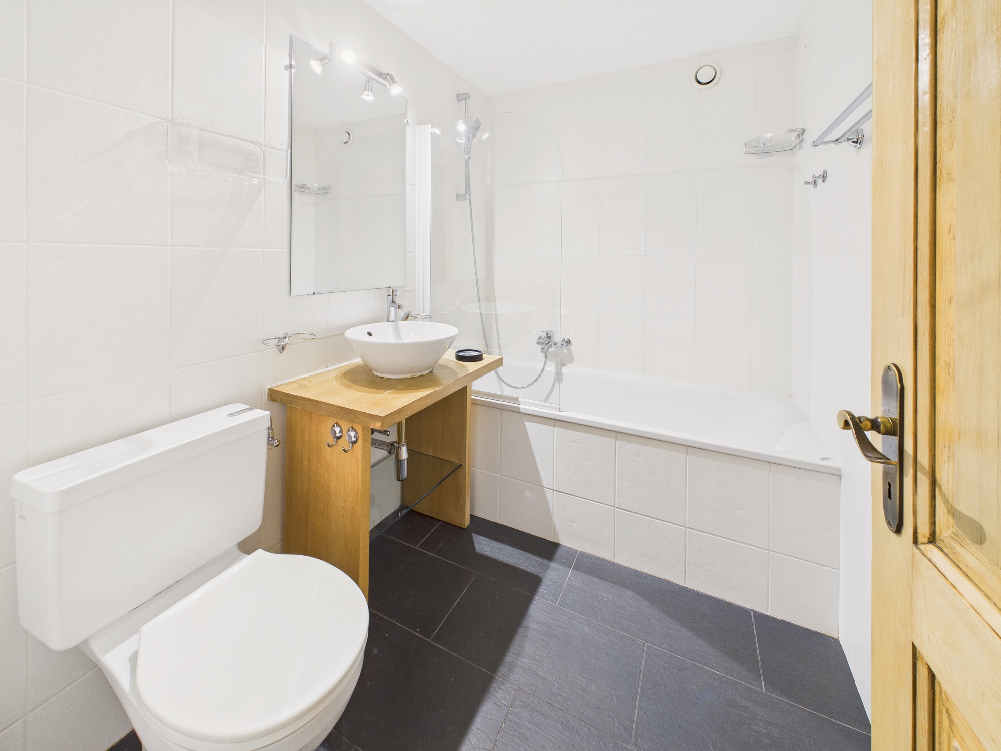 Kleines, helles Badezimmer mit Wanne, WC und Waschtisch