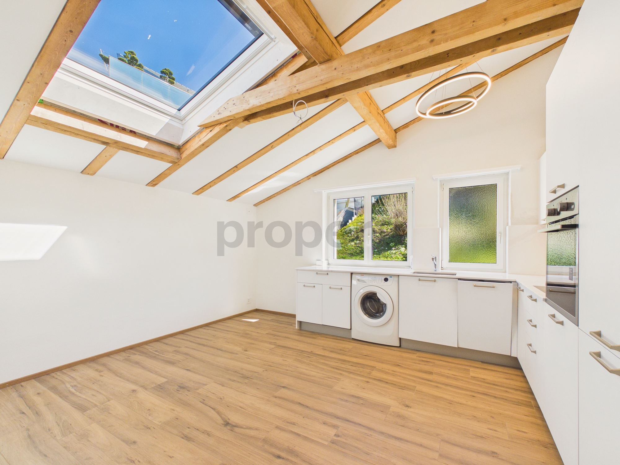 Helle Dachgeschossküche mit Holzsparren