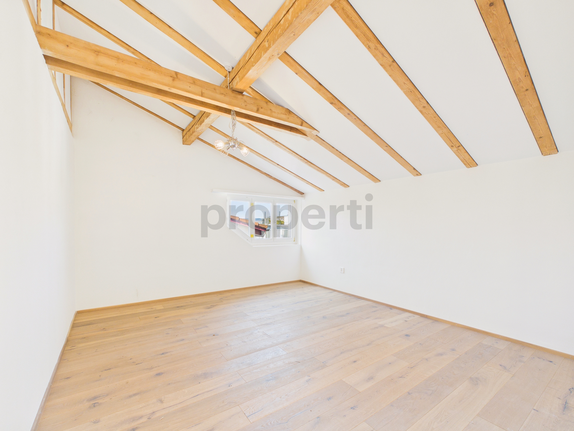 Dachgeschosszimmer mit sichtbaren Holzbalken