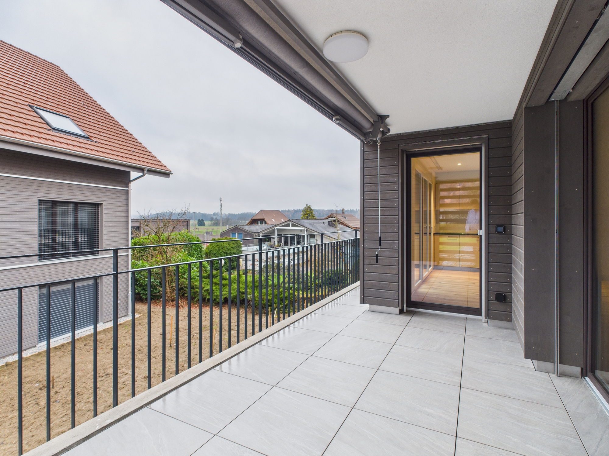 Überdachter Balkon mit Blick ins Grüne