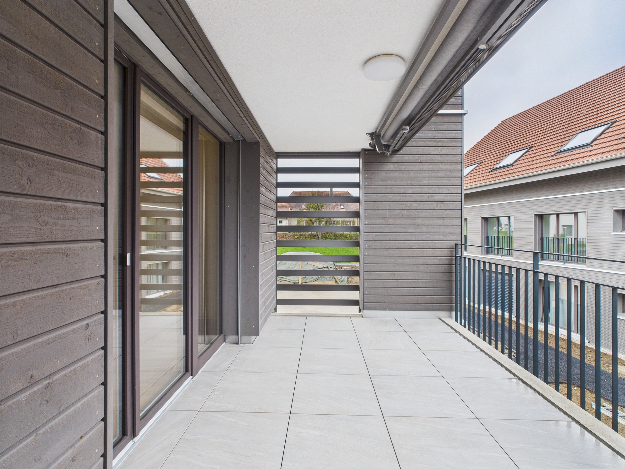Moderne Loggia mit Holzfassade und Blick auf den Innenhof