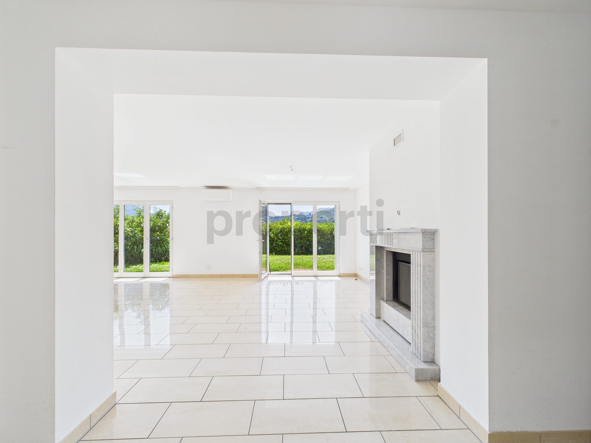 Heller Wohnraum mit Kamin und Blick ins Grüne