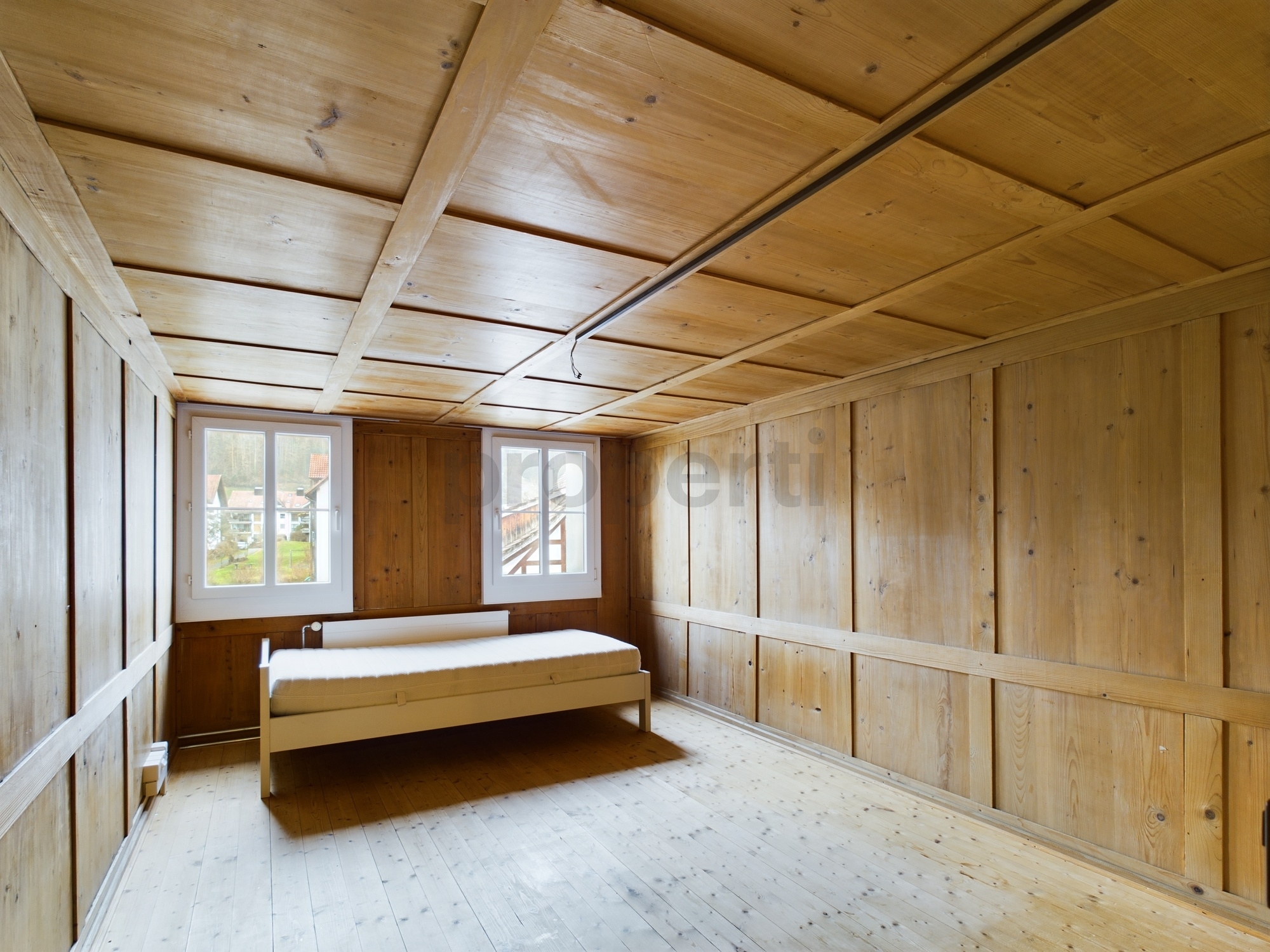 Holzverkleideter leerer Raum mit Bett