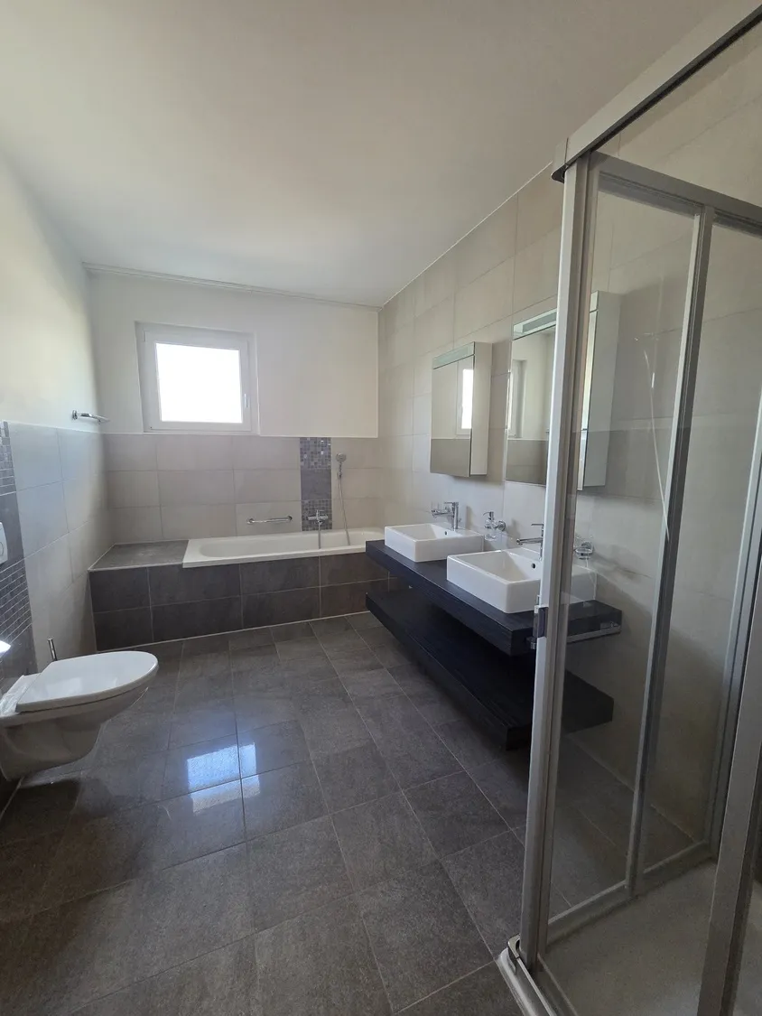 Modernes Badezimmer mit Wanne und Doppelwaschtisch