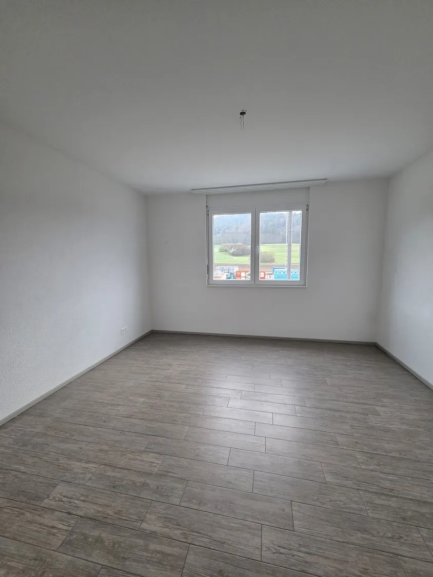 Leerer, heller Raum mit Fliesenboden und Fenster
