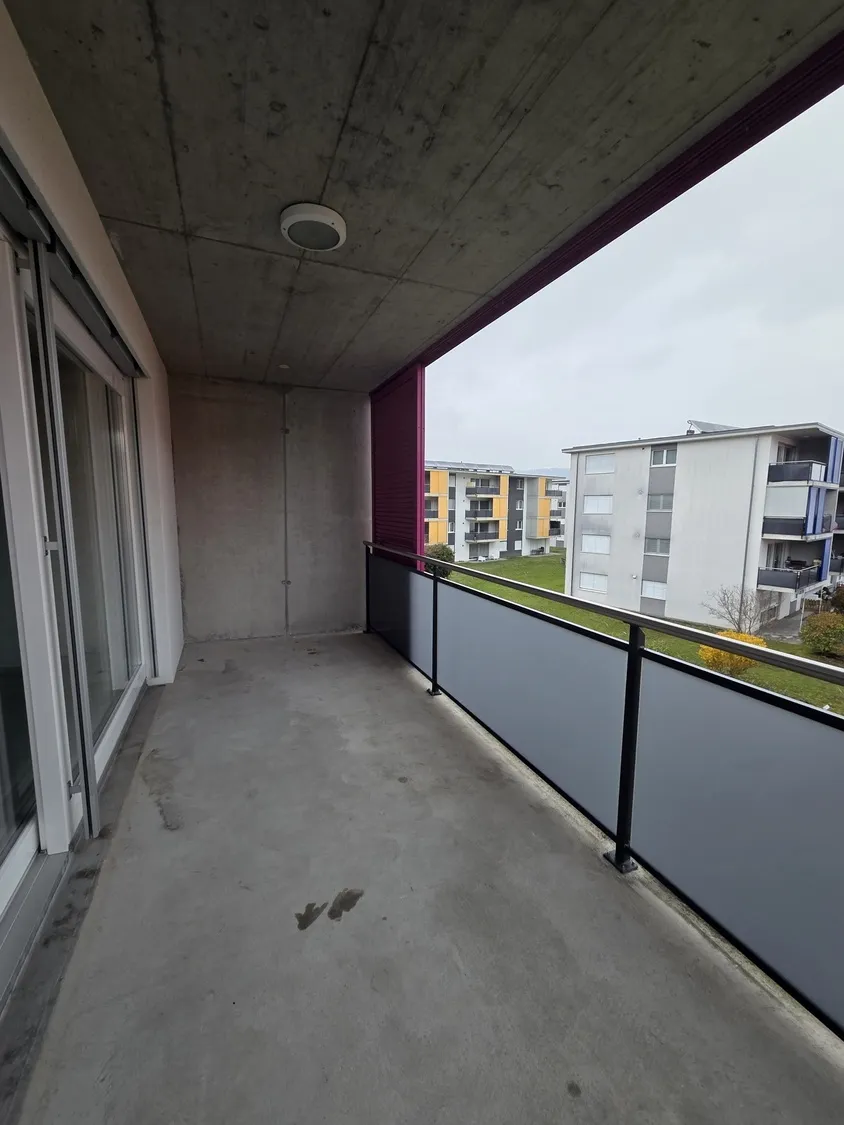 Balkon mit Betonoptik und Blick auf Wohnanlage