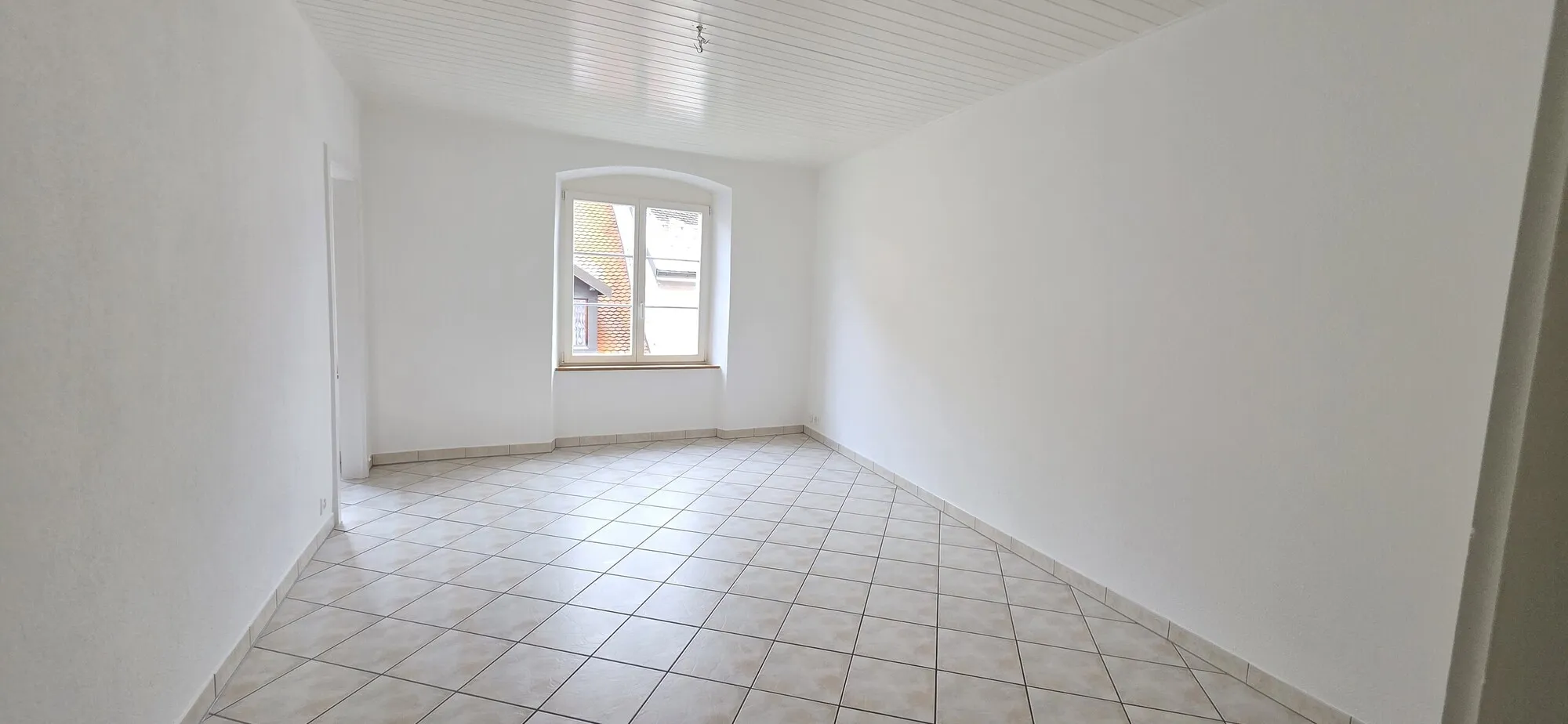 Heller leerer Raum mit Fliesenboden und Fenster