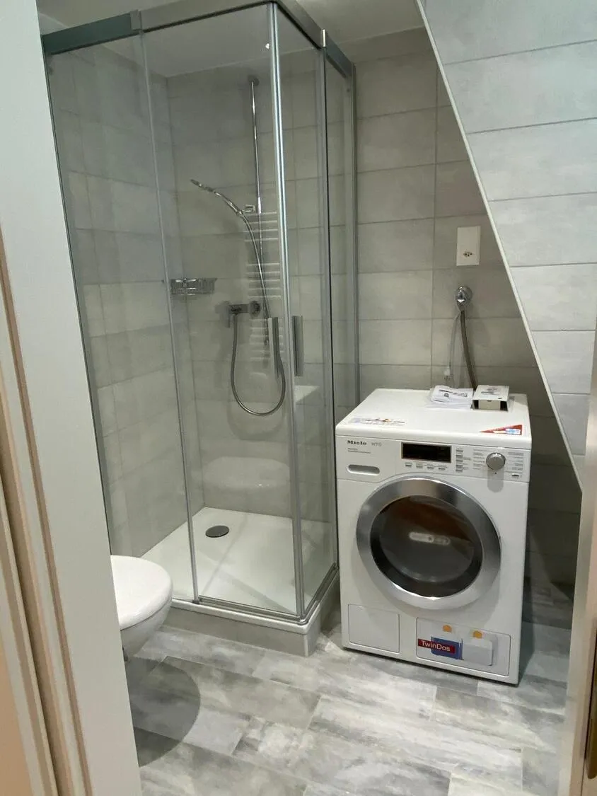 Badezimmer mit Dusche und Waschmaschine