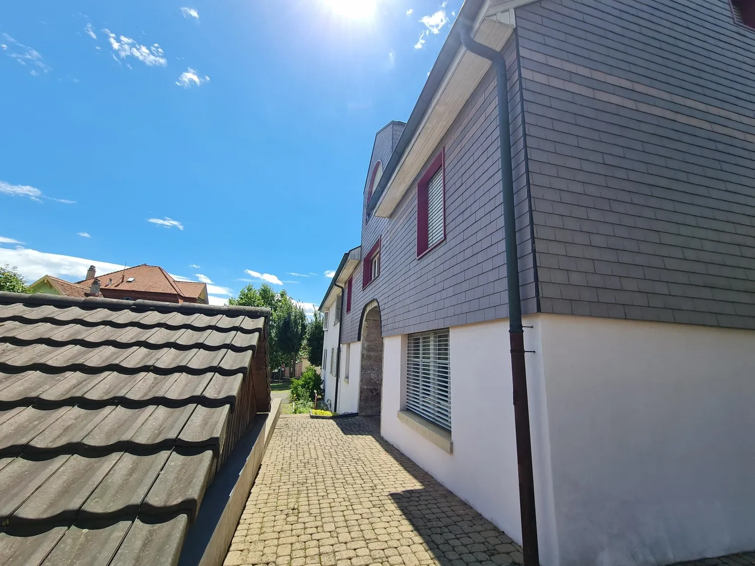 Außenansicht eines Wohnhauses mit schmalem Hofzugang