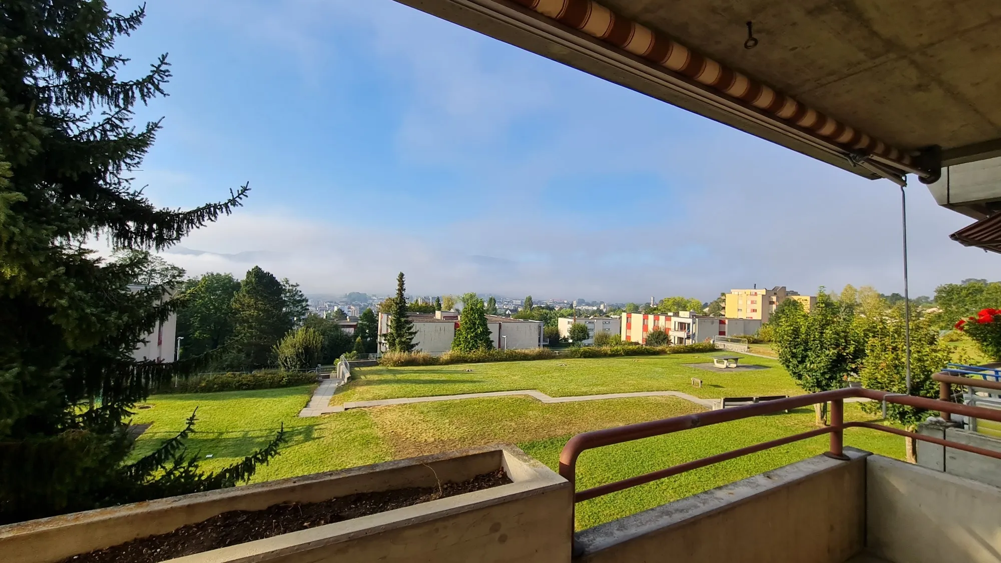 Balkon mit Blick ins Grüne und über die Siedlung