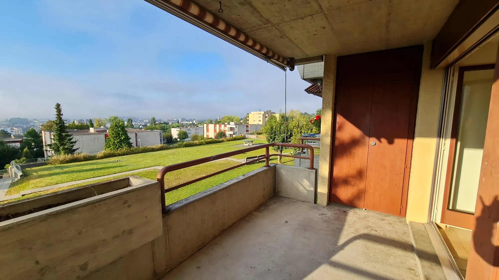 Balkon mit Blick ins Grüne und auf die Stadt