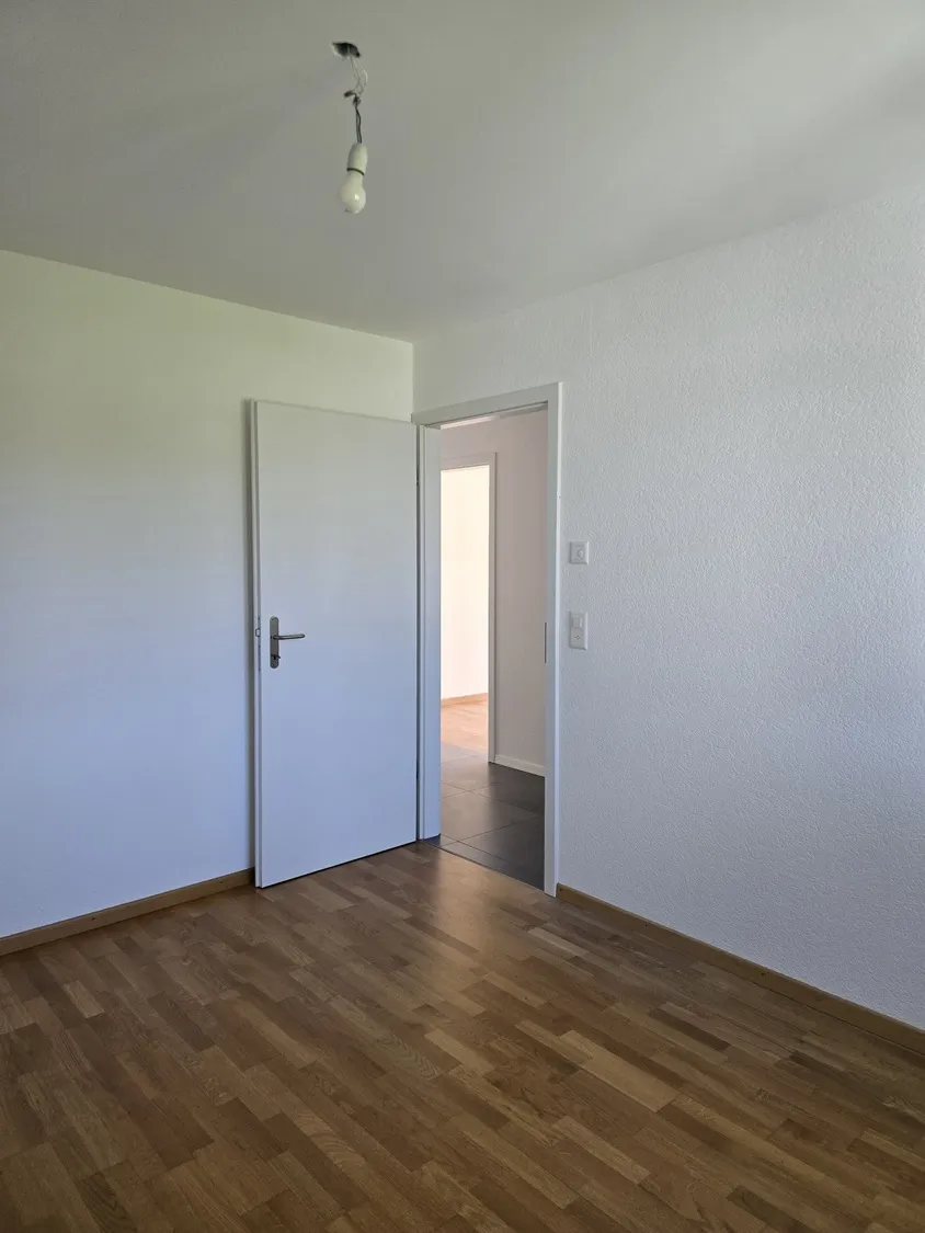 Leerer Raum mit Parkett und offener Tür