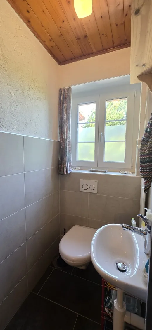 Kleines Badezimmer mit Holzdecke und Fenster