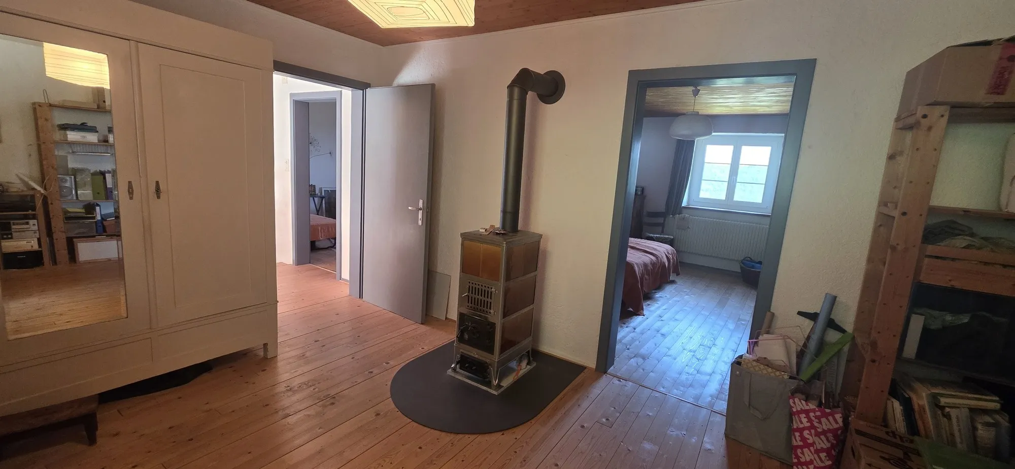 Wohnraum mit Holzofen und Durchgang zu Schlafzimmer