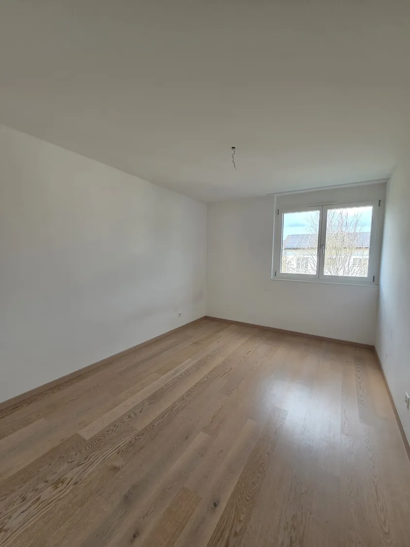 Leeres Zimmer mit Fenster und Parkettboden